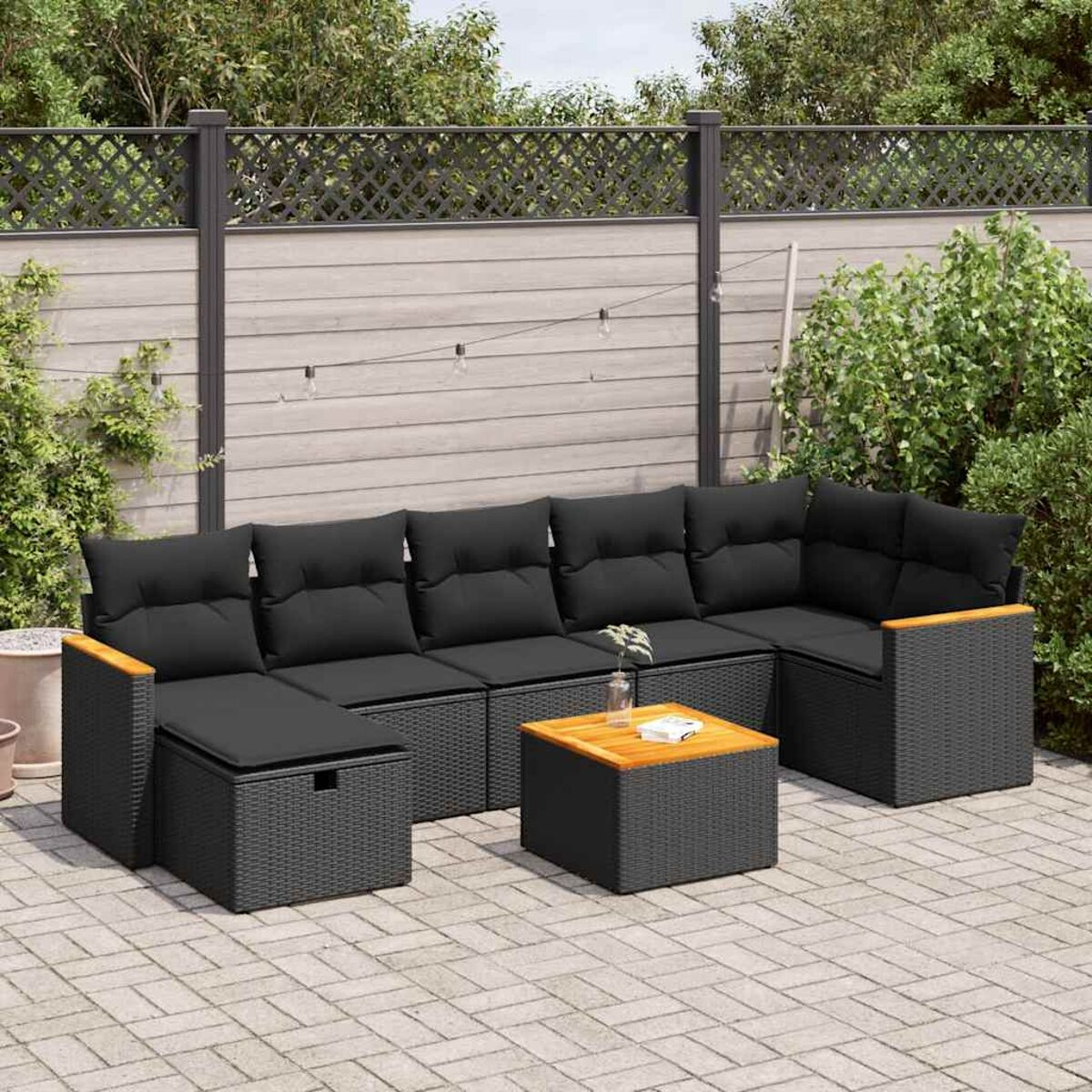 Ein schwarzes Outdoor-Ecksofa-Set mit einem Holztisch. Das Set hat schwarze Kissen. Die Umgebung ist draußen.