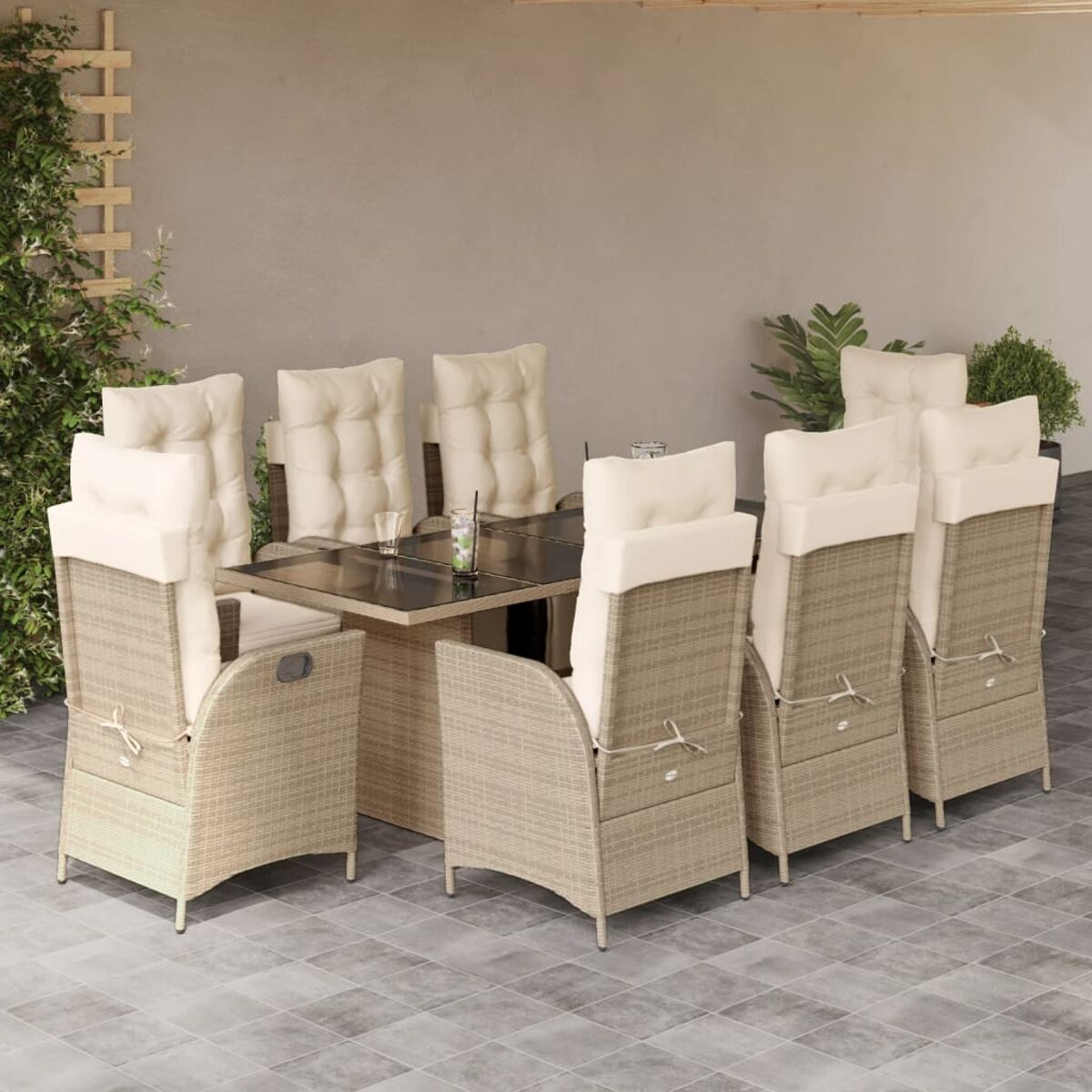 Sedie in rattan beige con cuscini color crema circondano un tavolo con piano in vetro. Ambiente esterno, vicino a un muro.