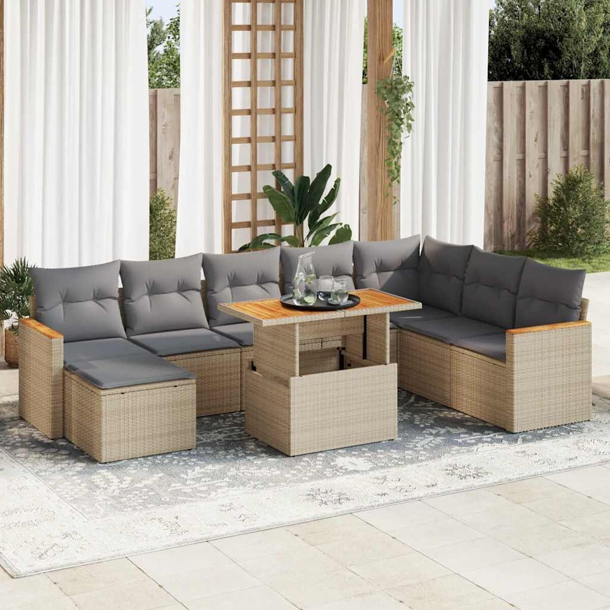 Set di mobili da patio con cuscini grigi e tavolo sollevabile su tappeto fantasia.