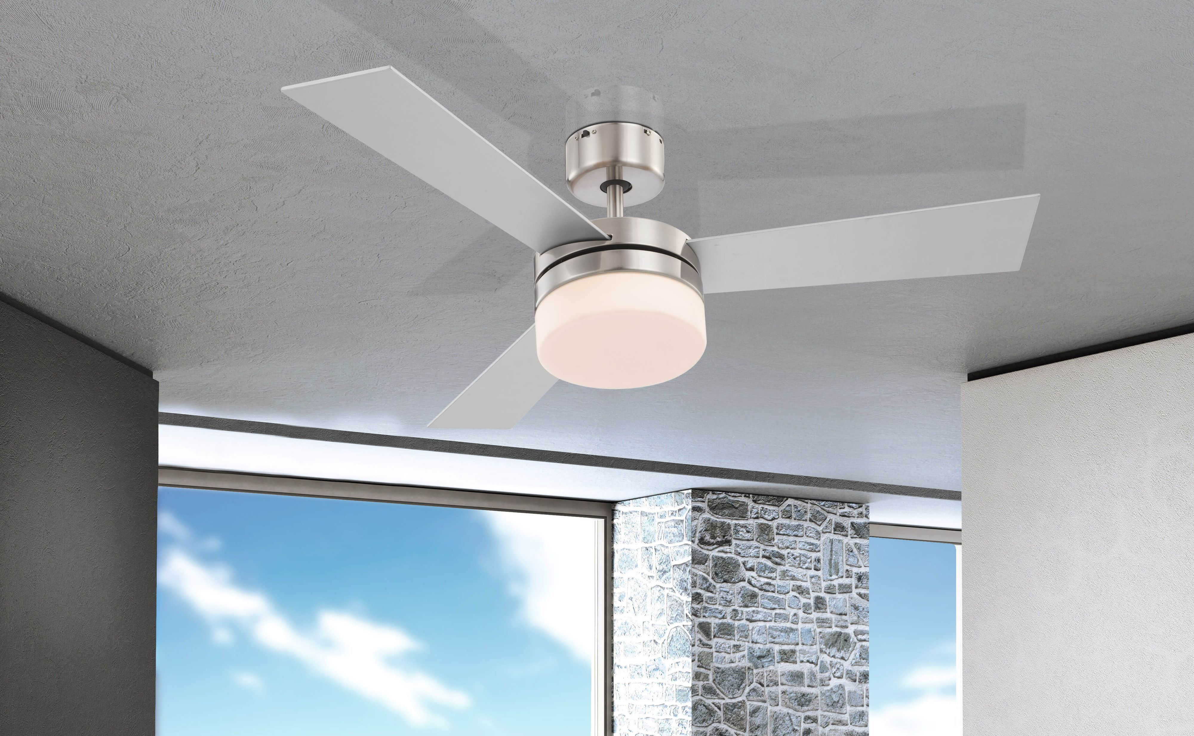 Ein Deckenventilator mit weißen Flügeln und einer zentralen Leuchte vor grauem Hintergrund.