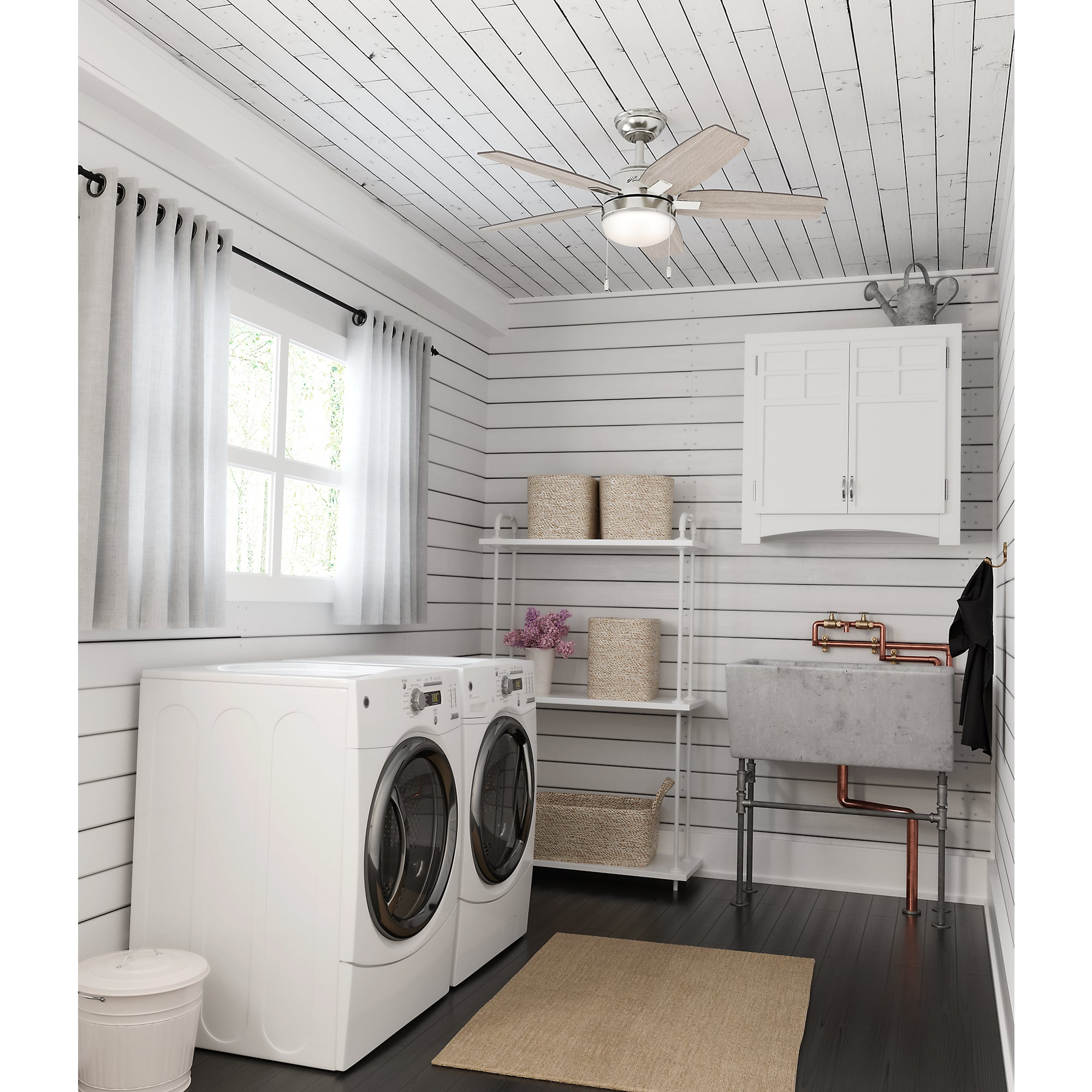 Waschküche mit Waschmaschinen, Waschbecken und Deckenventilator.