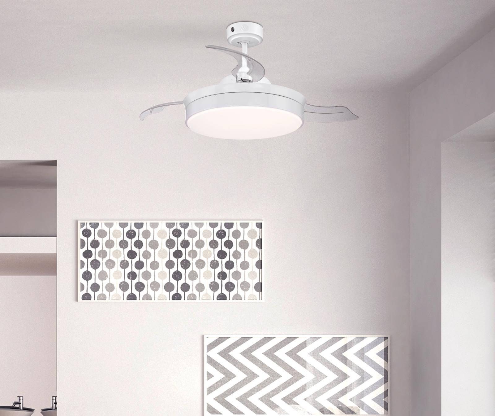 Weißer Deckenventilator mit Licht und zwei hängenden Bildern.