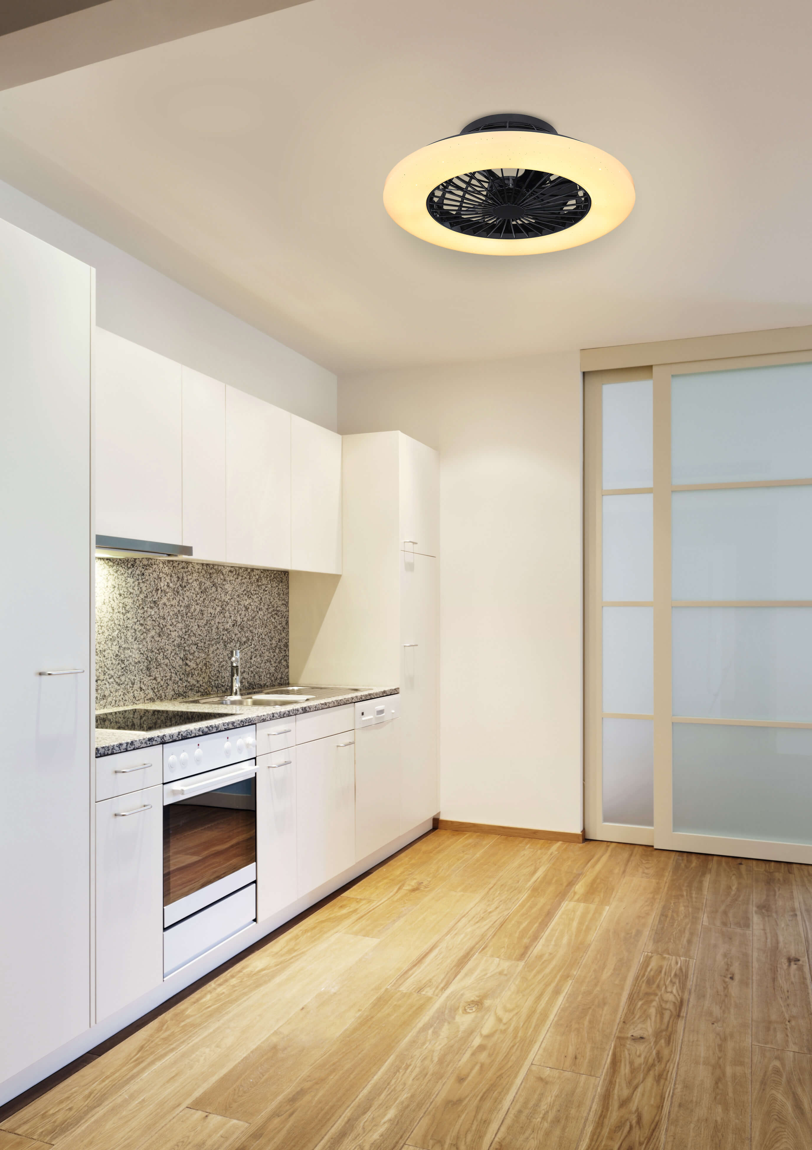 Küchenszene mit weißen Schränken, Holzboden und Deckenventilator.