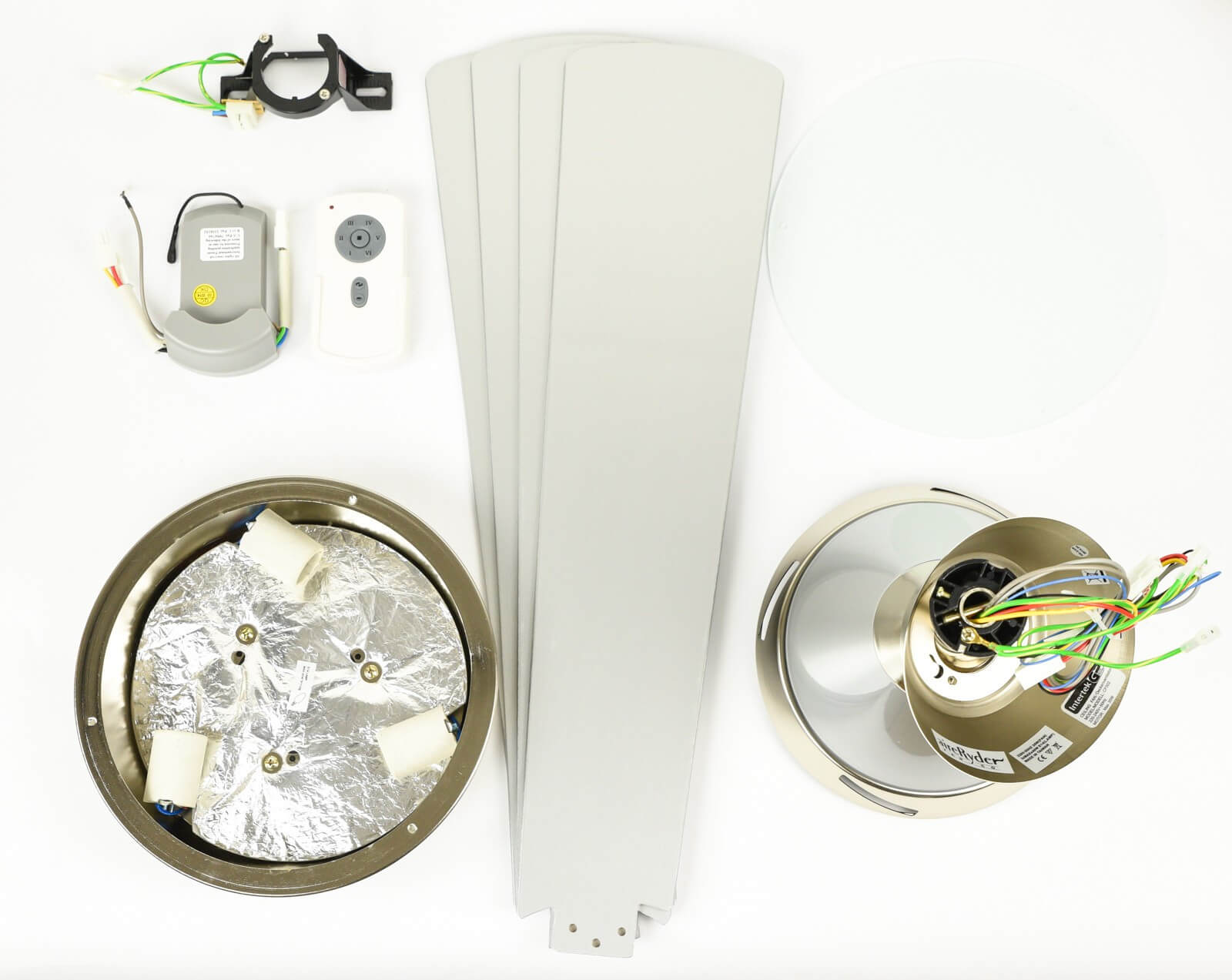 Ventilatore da soffitto smontato con pale, motore e altre parti su una superficie bianca.