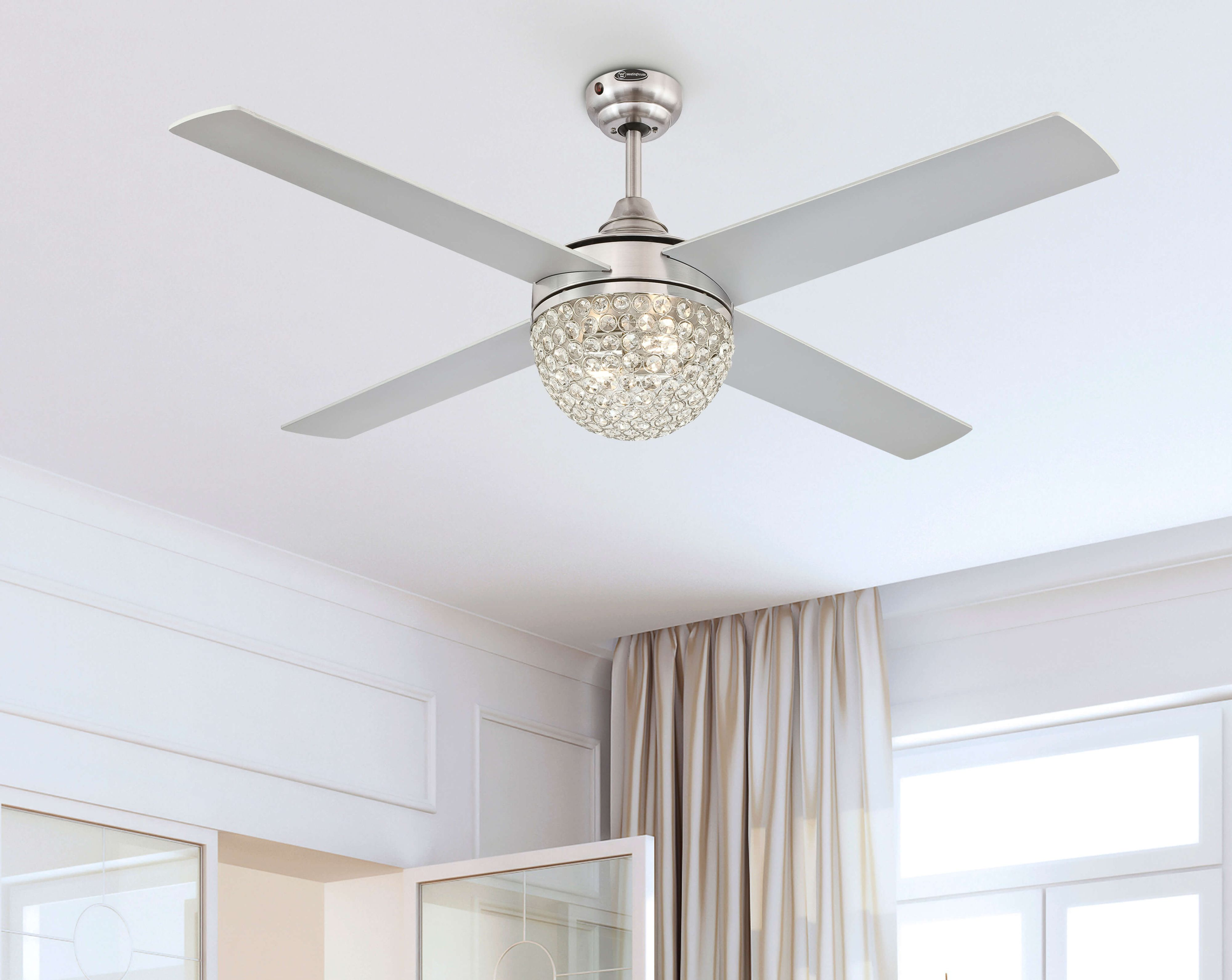 Deckenventilator mit kristallartiger Kugel, weißen Flügeln und silbernem Finish. Von unten betrachtet.