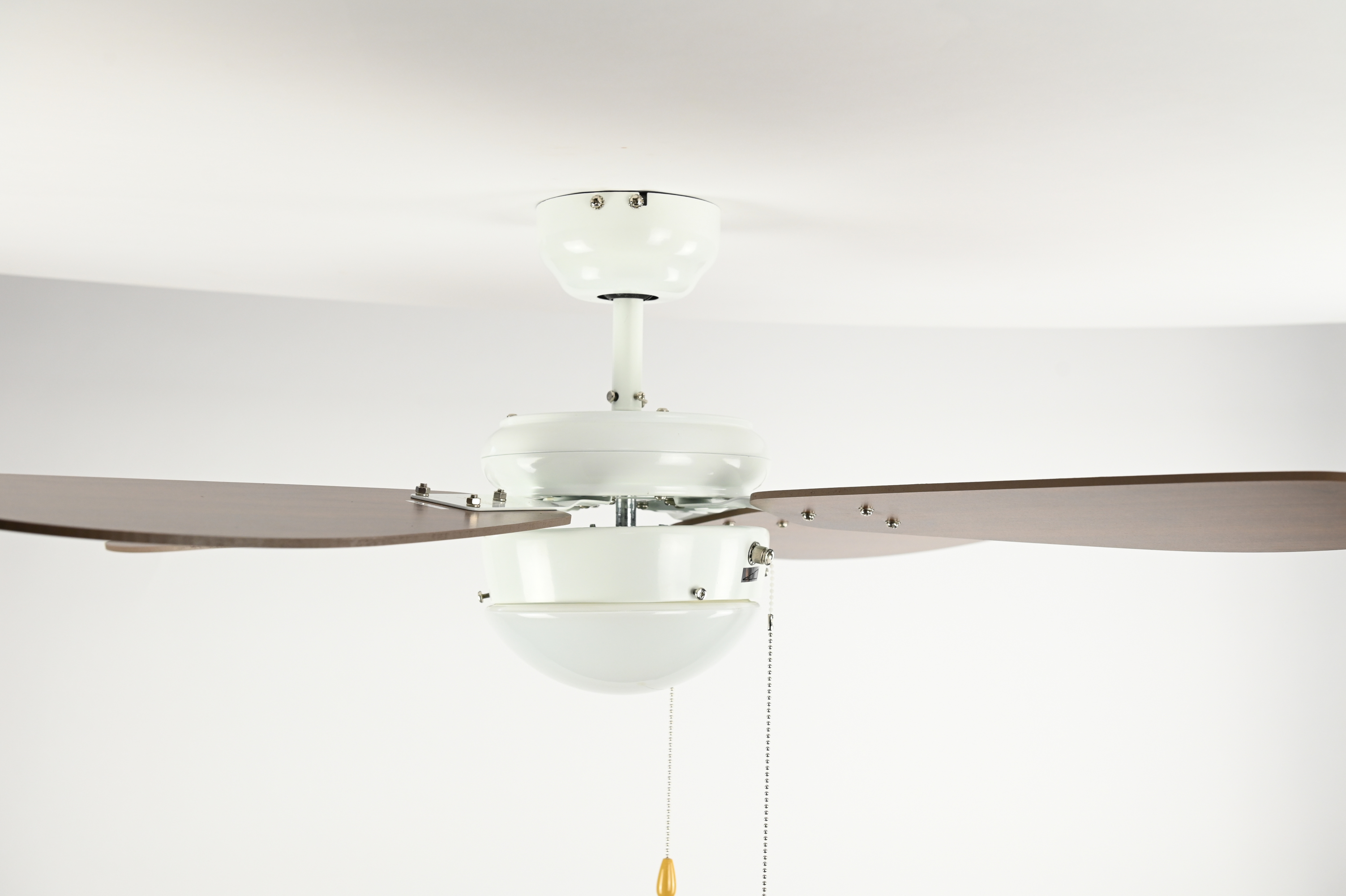 Ein weißer Deckenventilator mit vier braunen Flügeln, einem weißen Motorgehäuse und einem Licht.