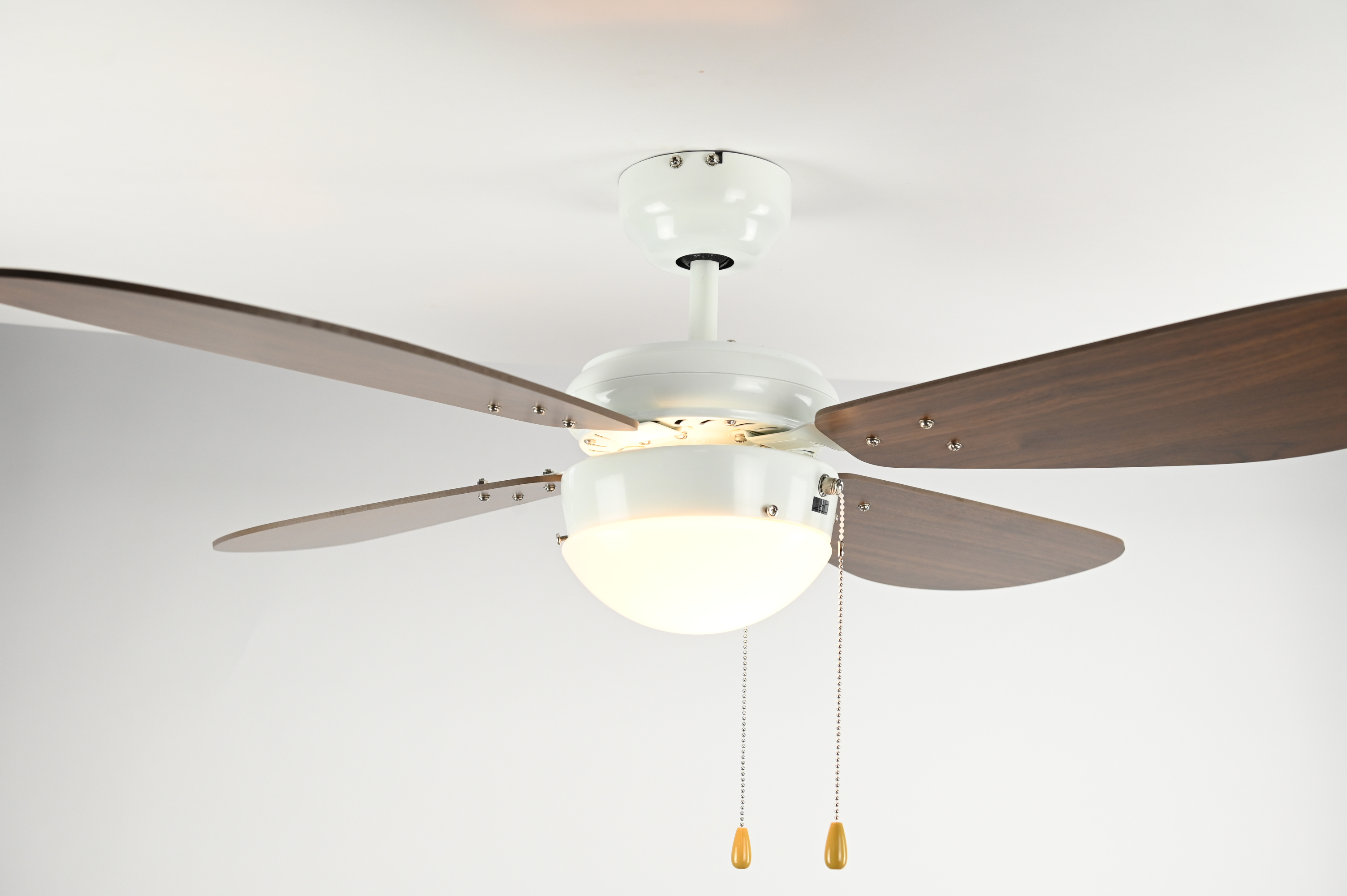 Ein Deckenventilator mit vier braunen Flügeln, weißem Gehäuse und einer beleuchteten Leuchte.