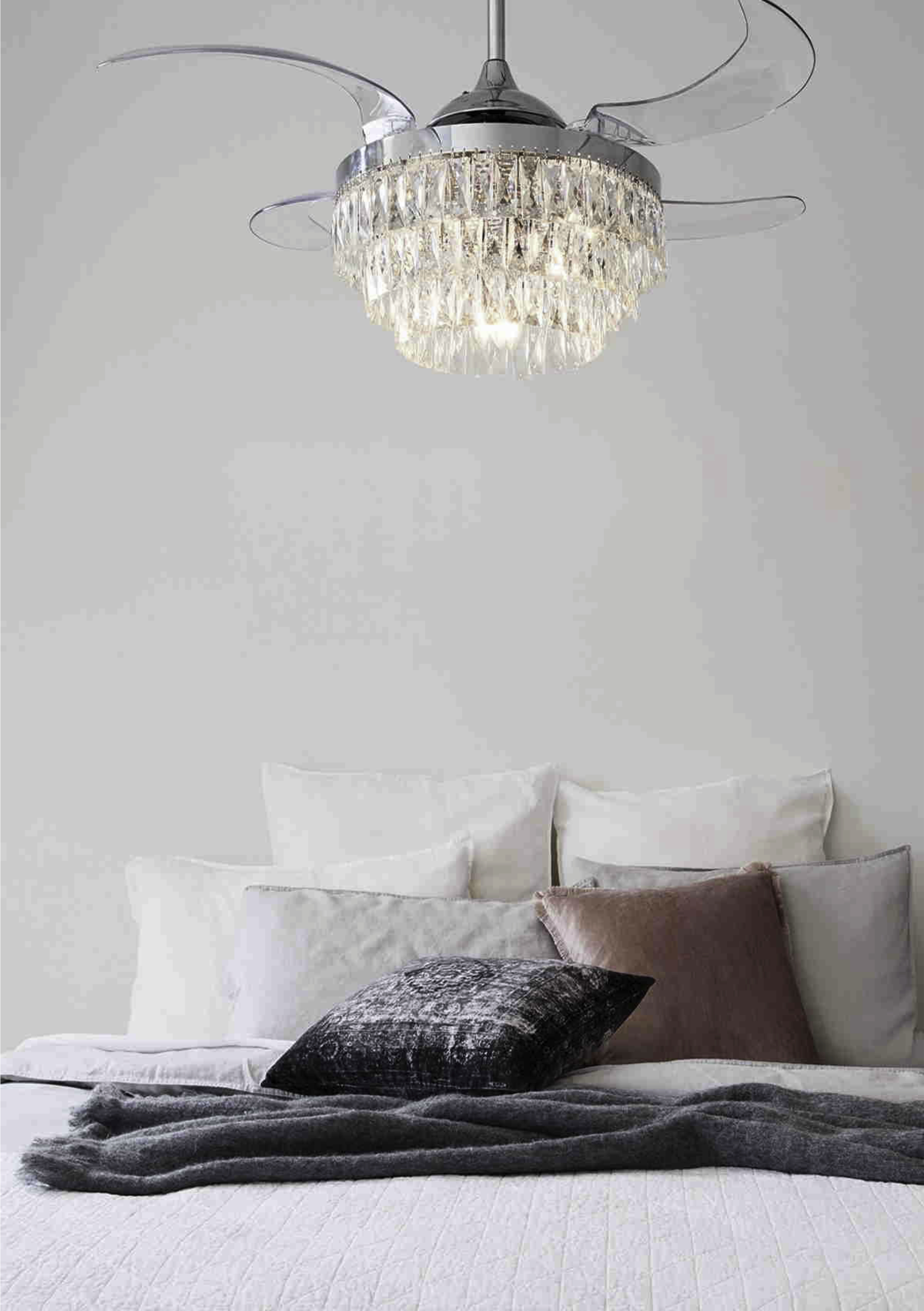 Schlafzimmer mit Kronleuchter-Deckenventilator über Bett mit Kissen.