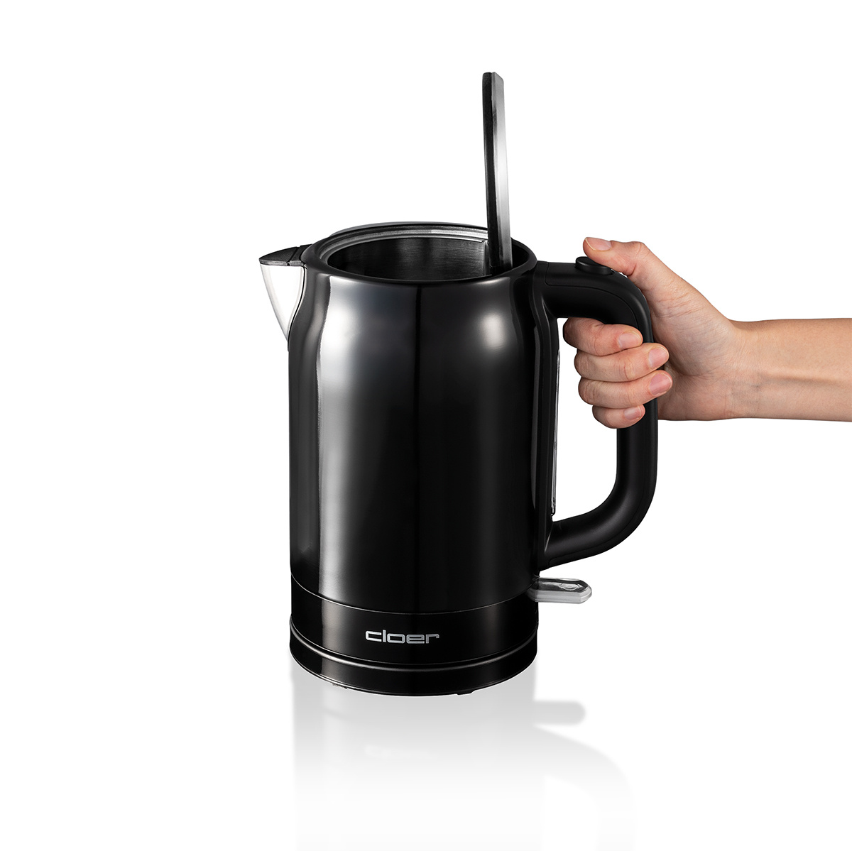 Bollitore elettrico nero, coperchio aperto, mano sul manico. Interno visibile.