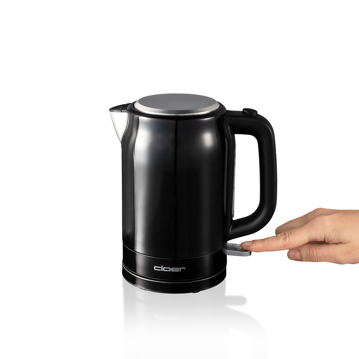 Un bollitore elettrico nero con coperchio argentato e una mano che preme l'interruttore.