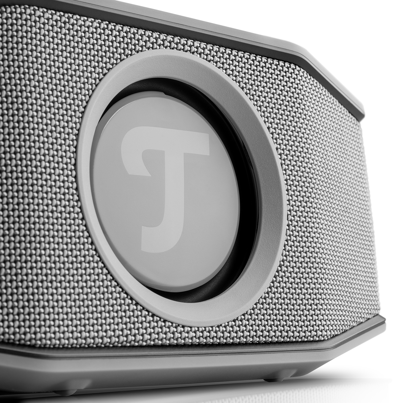 Gray speaker with a circular speaker cover and the Teufel logo. It is on a white surface.