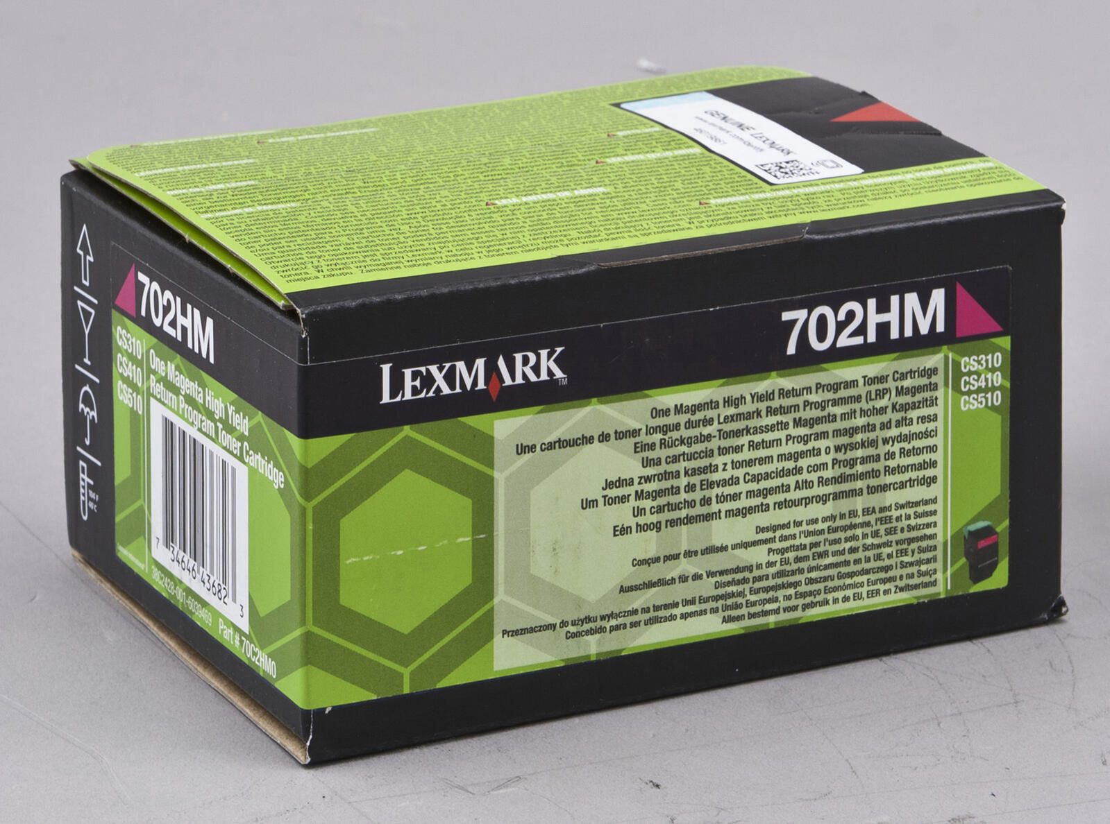 Lexmark 702HM Tonerkartuschenbox, schwarz mit grünem Deckel. Text in mehreren Sprachen.