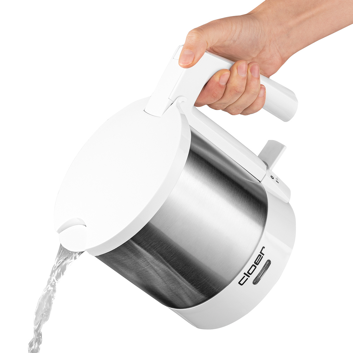 Una mano vierte agua de una tetera blanca y plateada. La tetera tiene un botón negro.