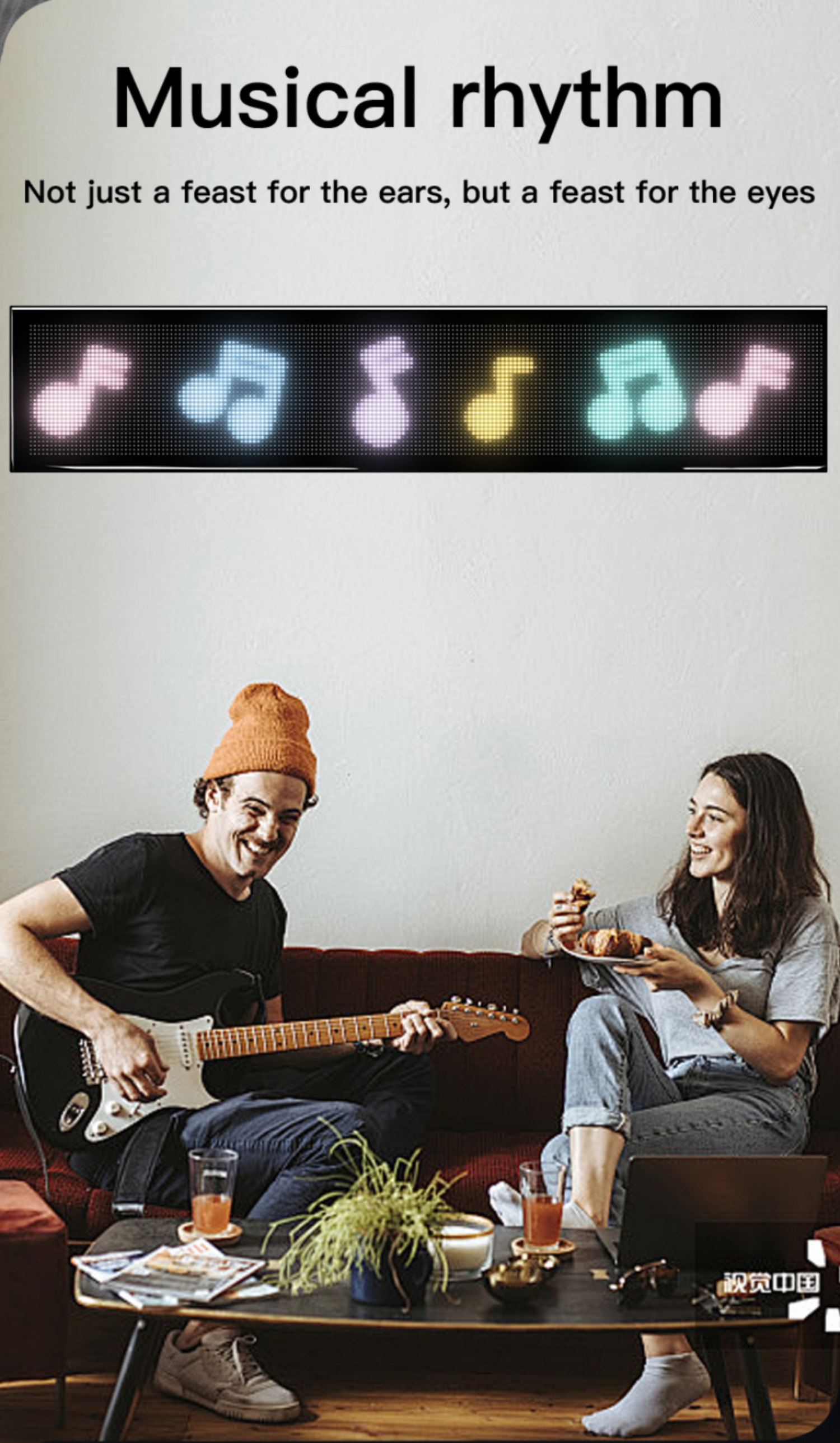 Ein Mann spielt Gitarre und eine Frau isst, mit Musiknoten auf einem Bildschirm.