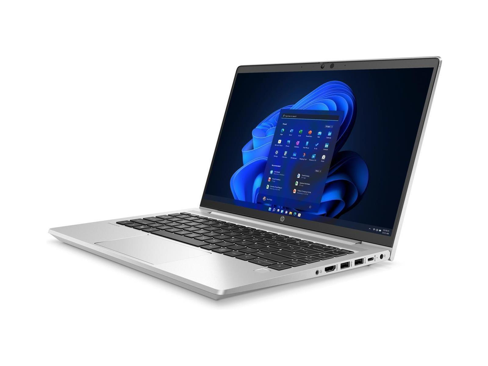 Offener silberner Laptop mit blauem Bildschirm. Der Schreibtisch ist weiß.