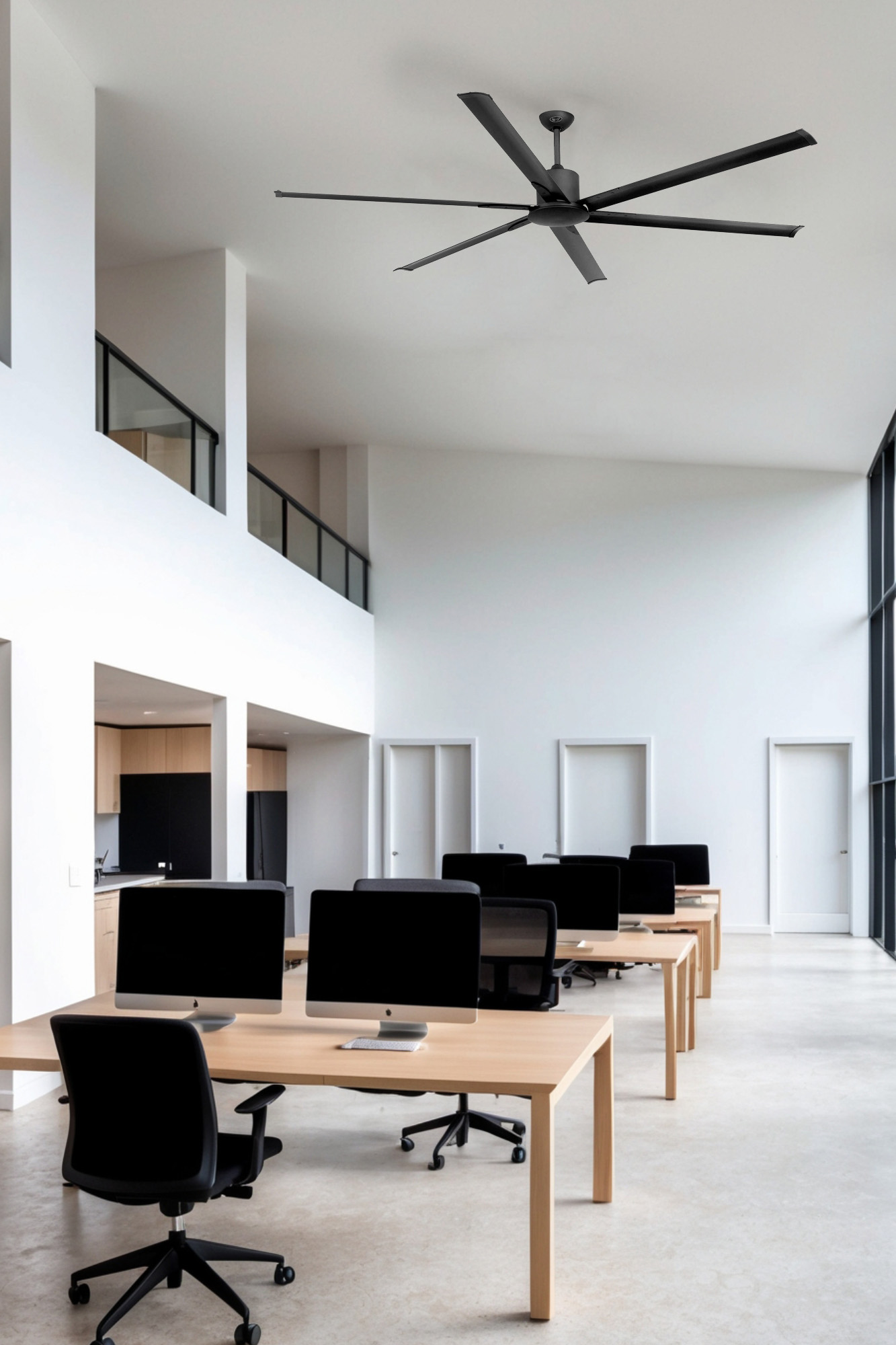 Moderner Büroraum mit Schreibtischen, schwarzen Stühlen und einem großen schwarzen Deckenventilator.