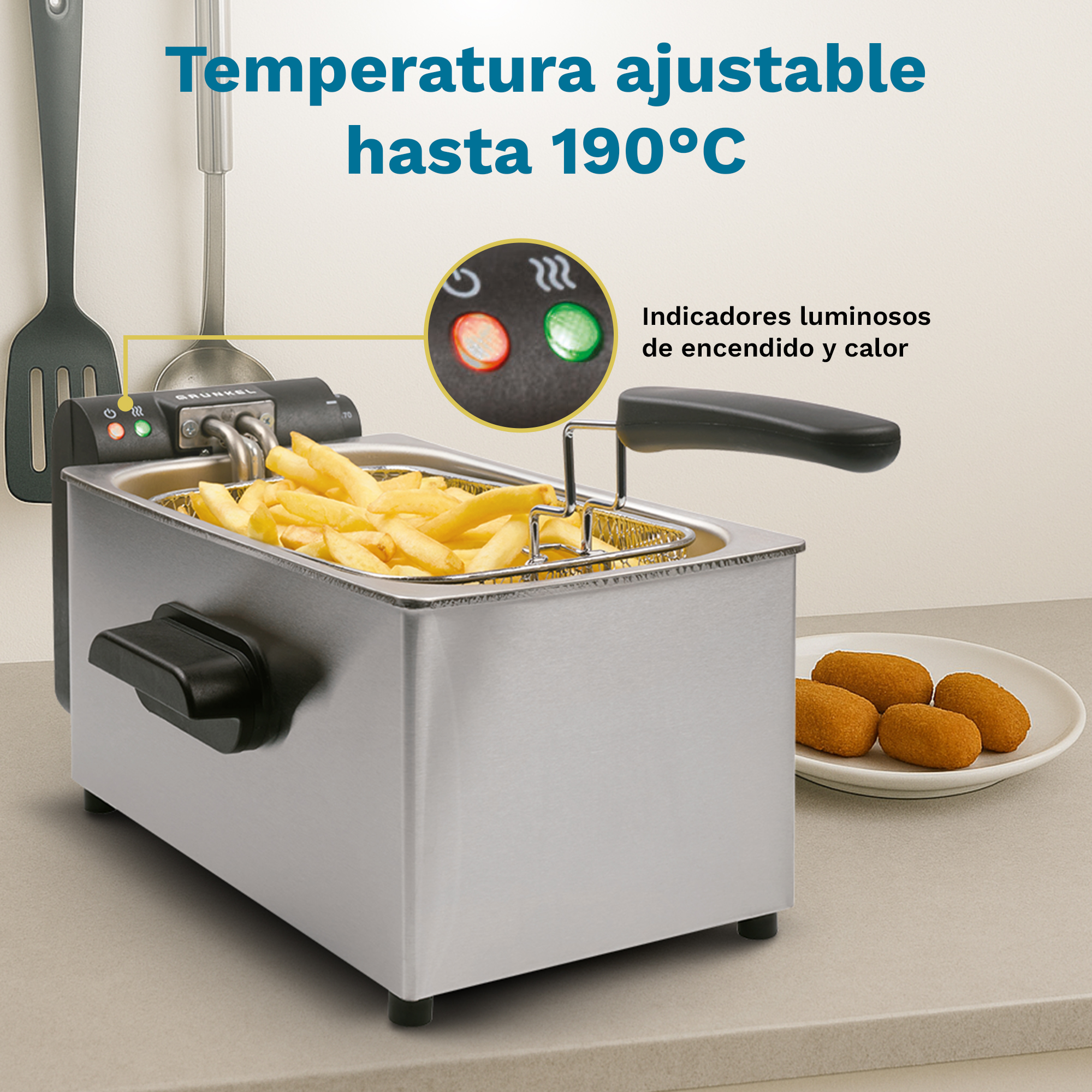 Una friggitrice argentata con patatine fritte e crocchette su un bancone.