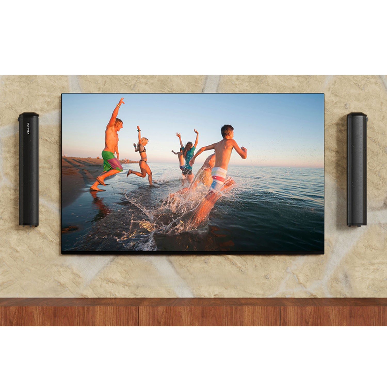 Des gens courant hors de l'eau sur une plage, la TV montre la scène. Deux enceintes noires de chaque côté.