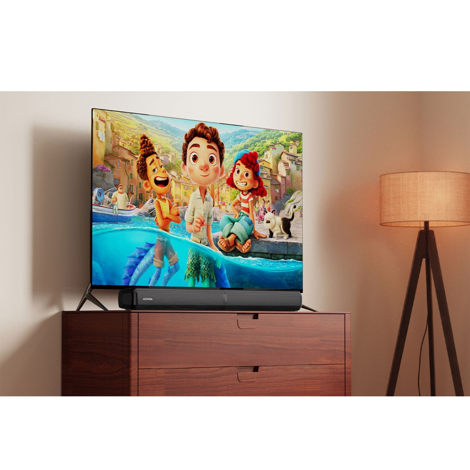 TV montrant un film d'animation avec des personnages. Barre de son sur le meuble. Lampe à droite.