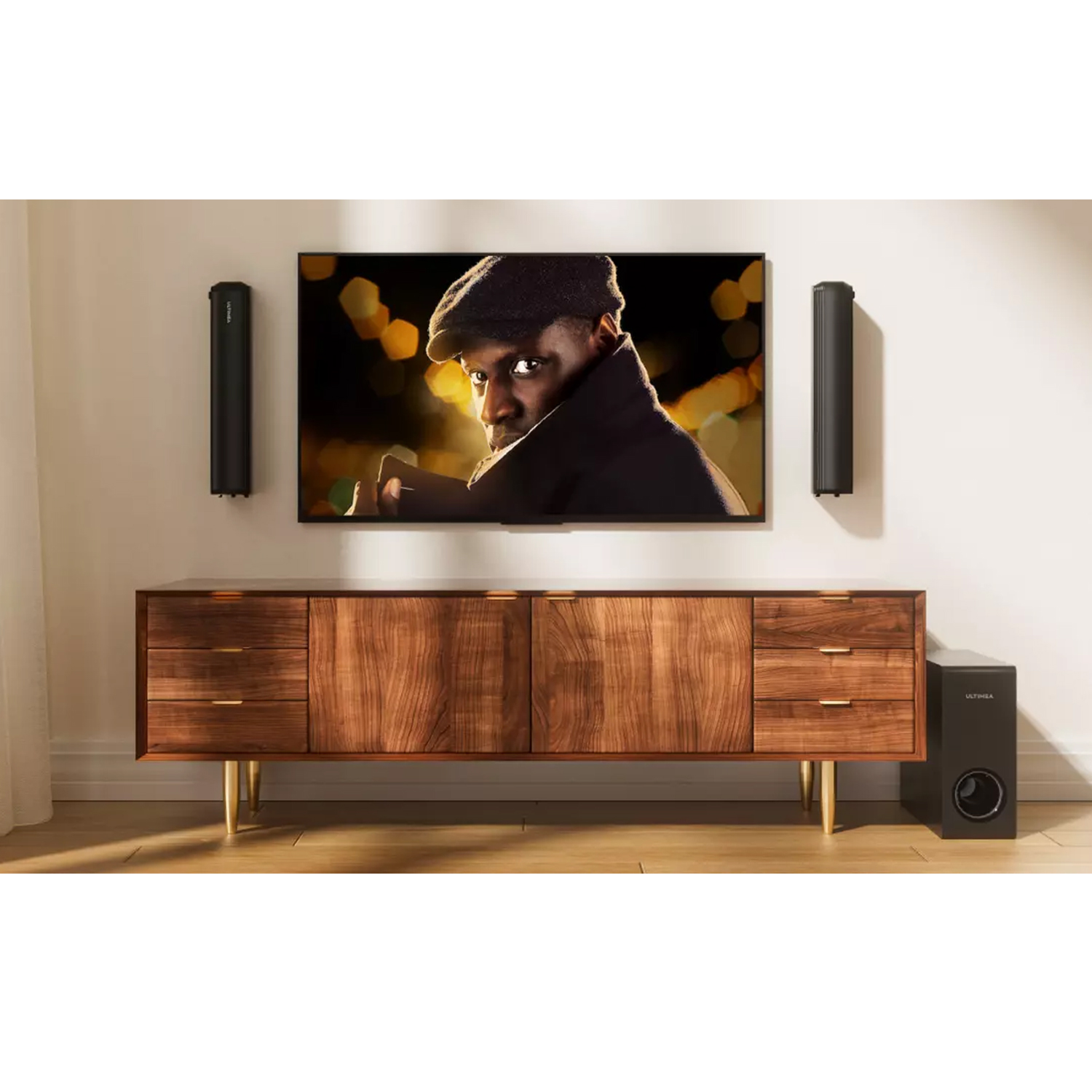 Ustawienie salonu z telewizorem, soundbarem, głośnikami i drewnianą szafką ze złotymi nogami.