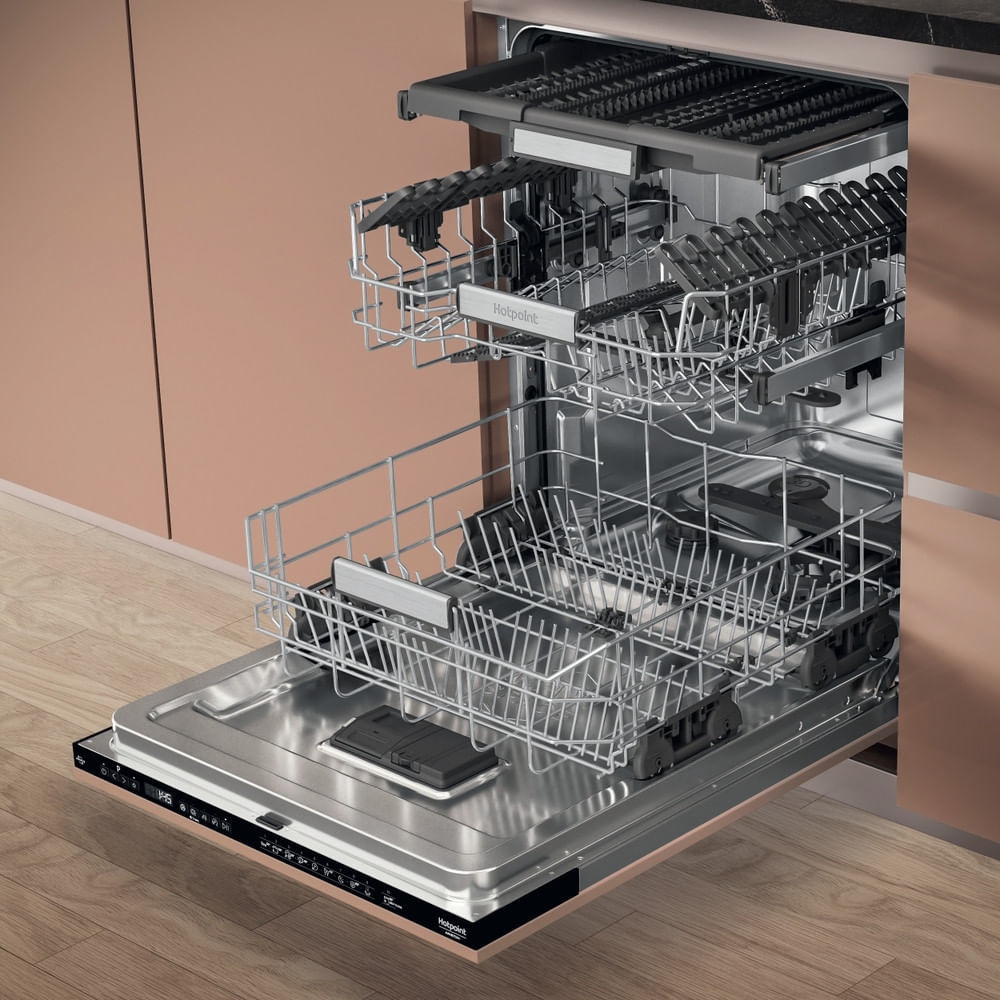 Lavastoviglie con porta aperta, che mostra cestelli e interno, in un mobile da cucina.