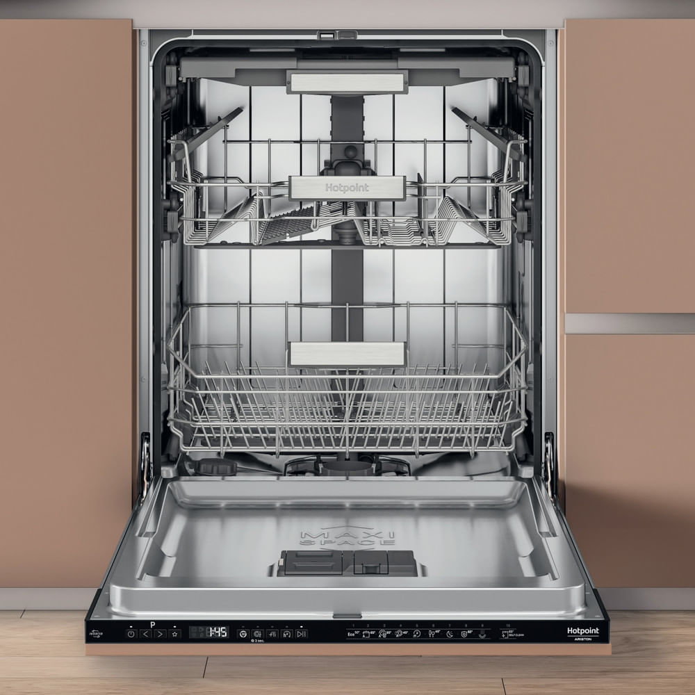 Una lavastoviglie aperta con cestelli e utensili all'interno, in un ambiente cucina.