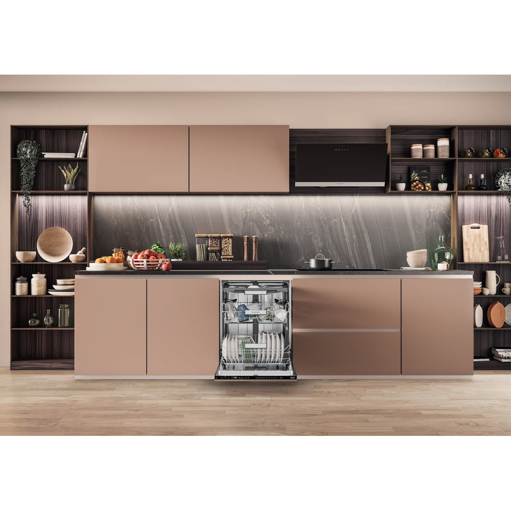 Una cucina moderna con la porta della lavastoviglie aperta, che mostra i piatti all'interno. Armadi rosa.
