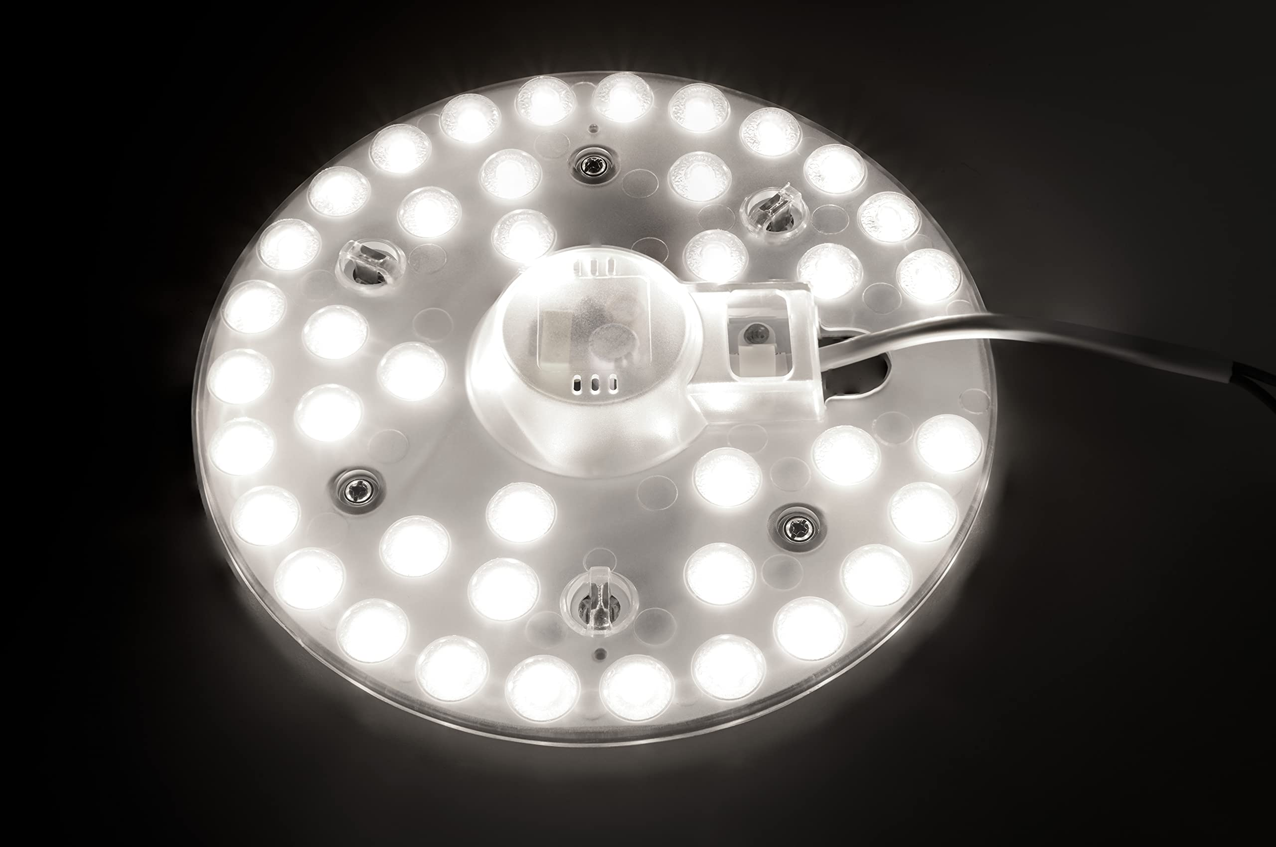 Ein kreisförmiges LED-Panel mit hellweißen Lichtern. Die Rückseite ist sichtbar, montiert auf dunkler Oberfläche.