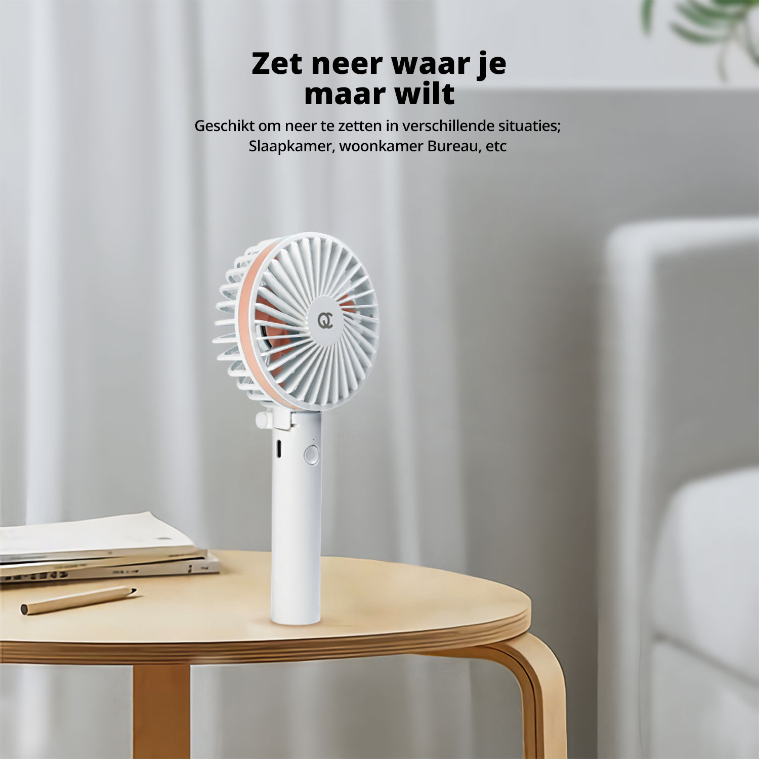 White portable fan placed on a table, with a blurred background.