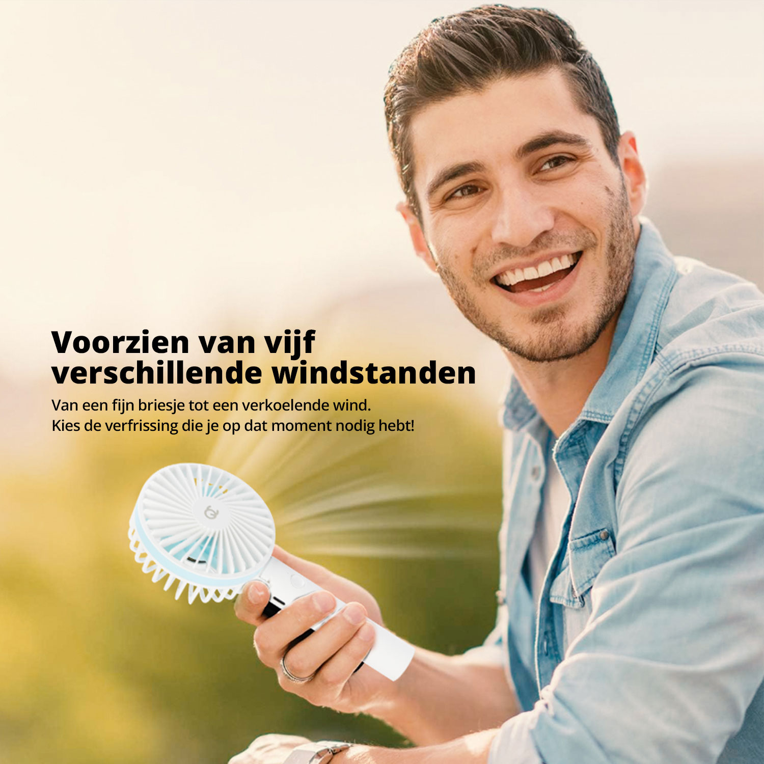 Man smiling while holding a white and blue portable fan.