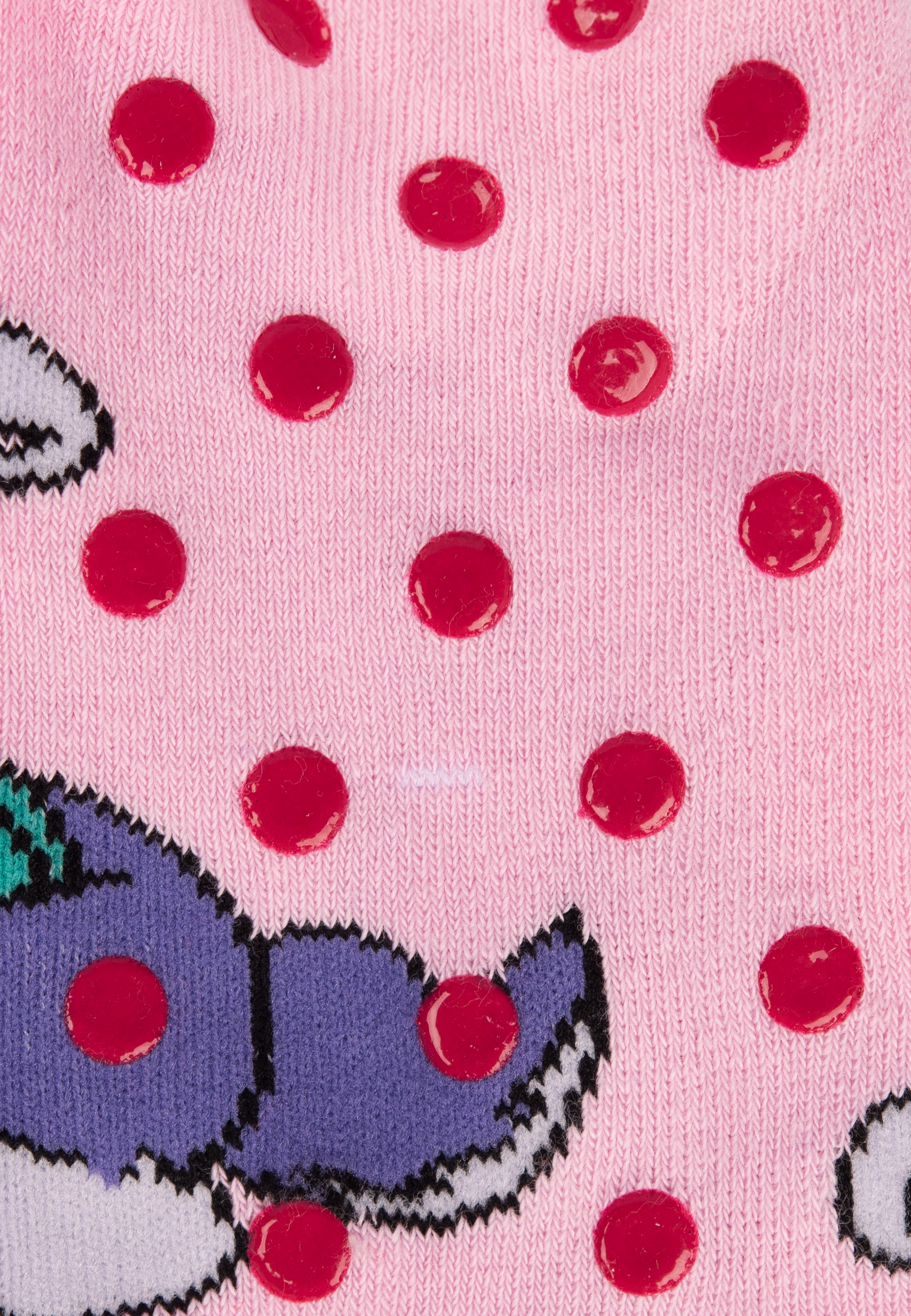 Rosa Socken mit roten Tupfen und Zeichentrickfiguren. Weißer Hintergrund mit Nahaufnahme.