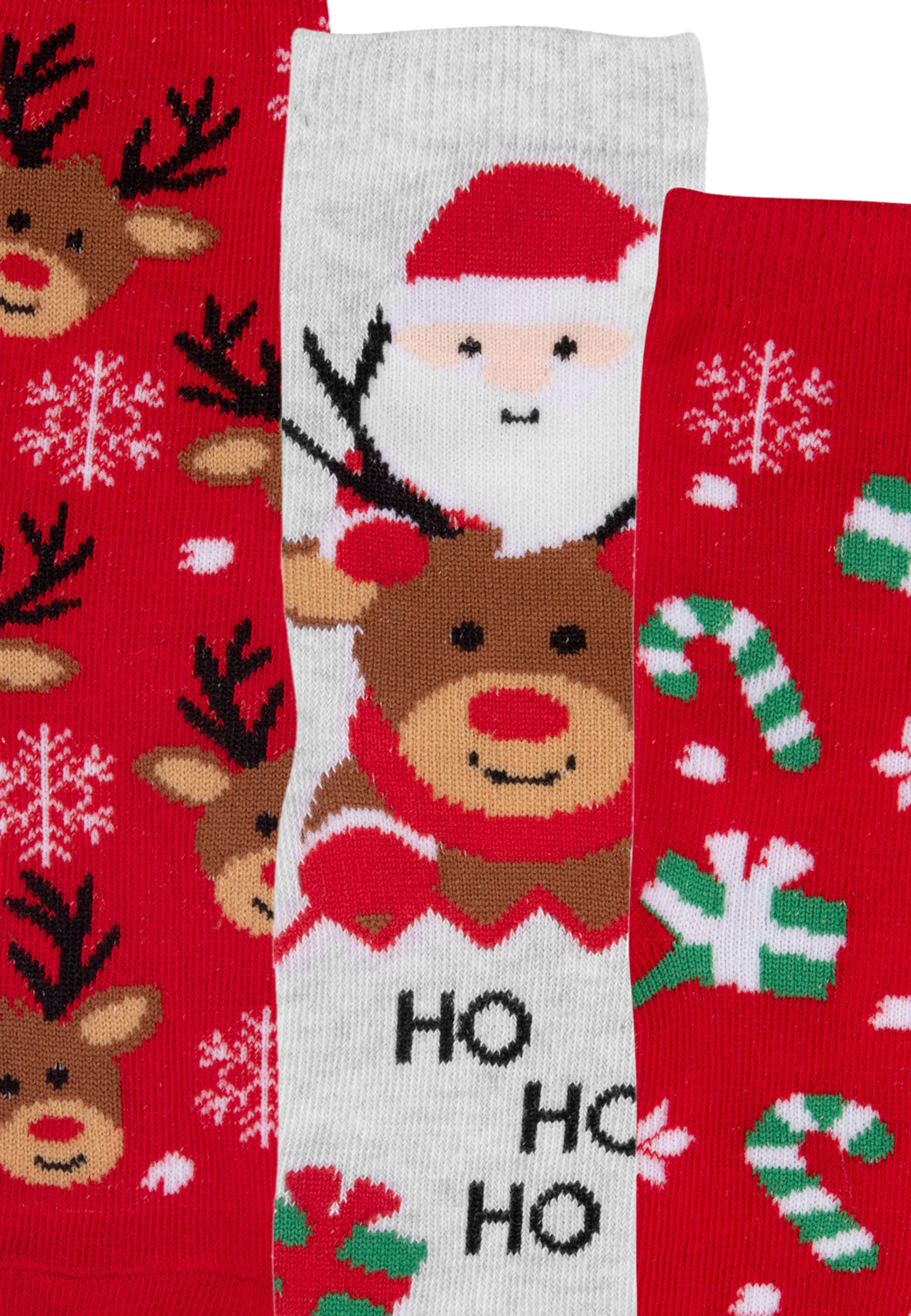 Drei Paar Weihnachtssocken mit festlichen Mustern.