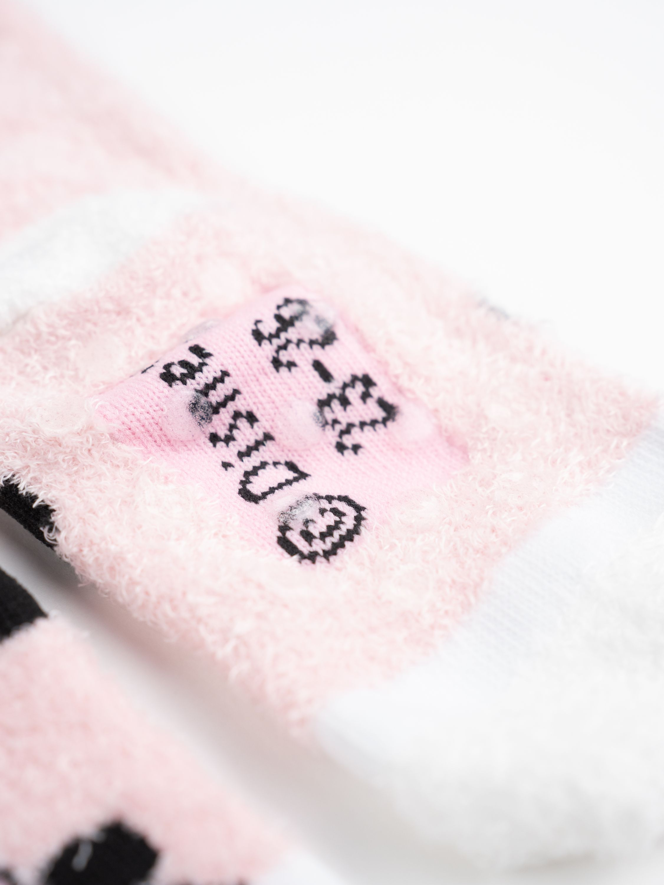 Rosa und weiße Socken. Disney-Logo und Größenetikett.