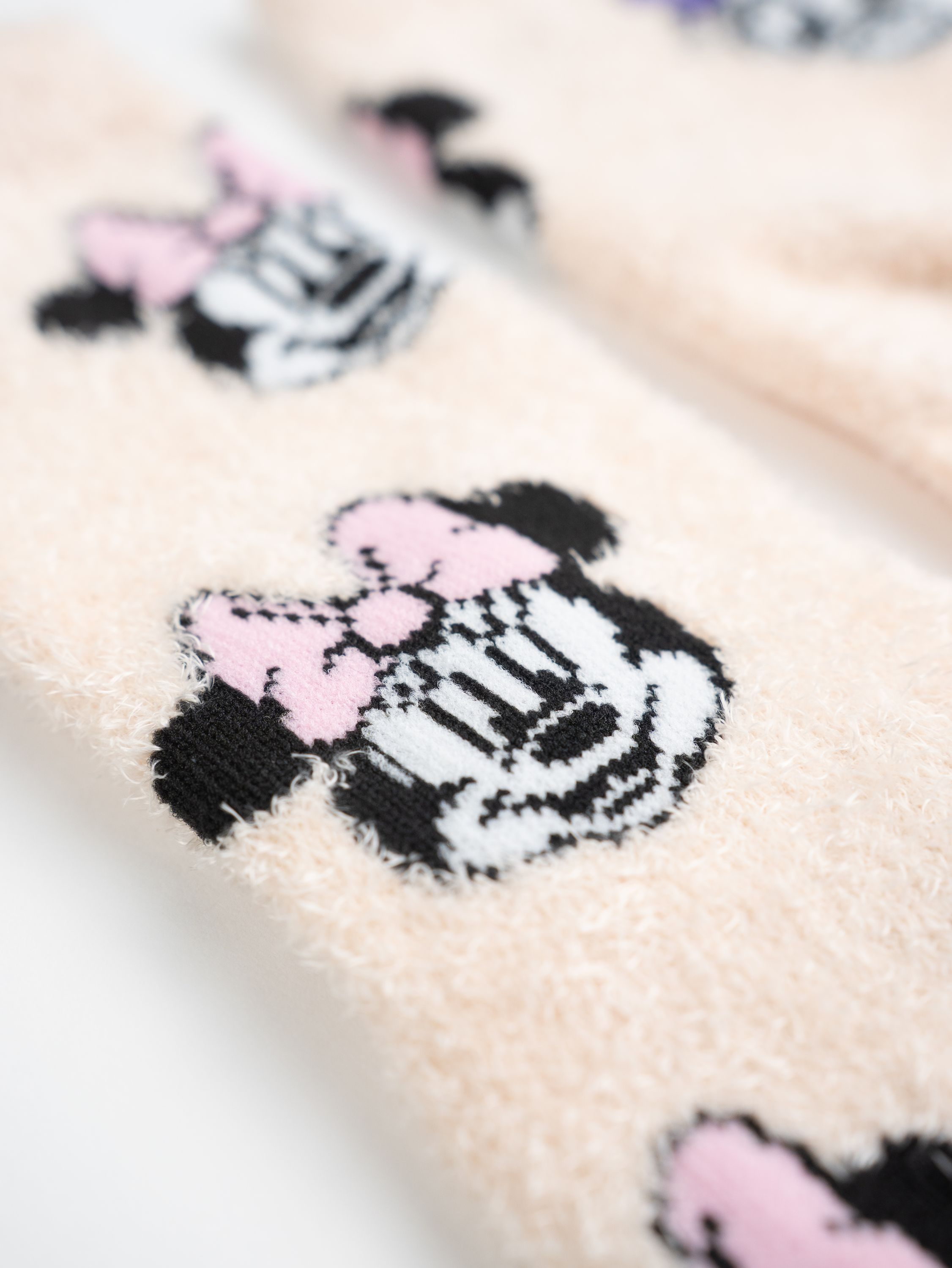 Paar Socken mit Minnie Mouse Design. Weißer Hintergrund.