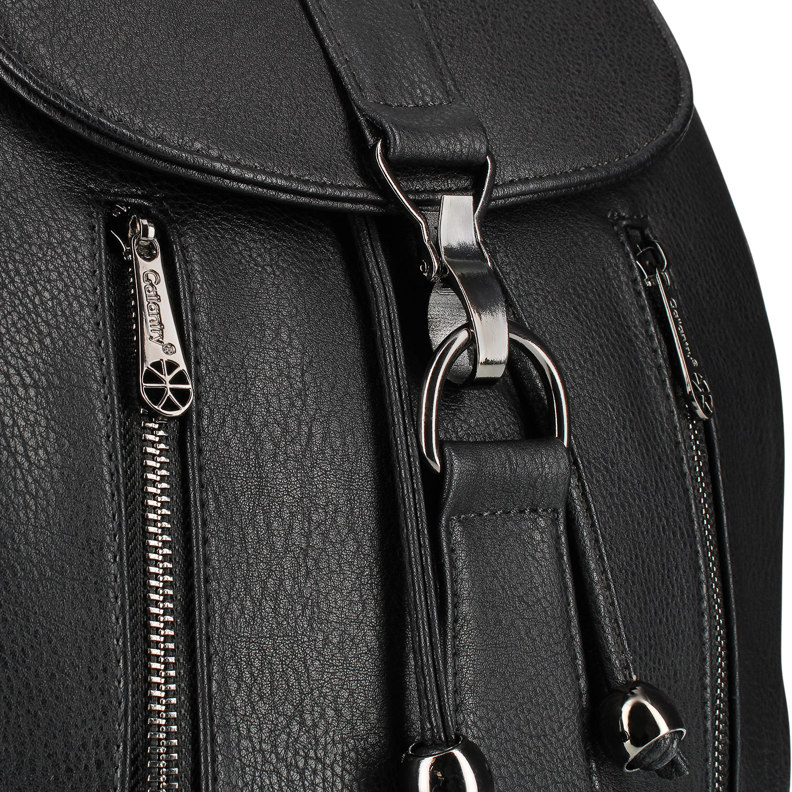 Nahaufnahme eines schwarzen Rucksacks mit silbernen Reißverschlüssen und einem großen Metallring.