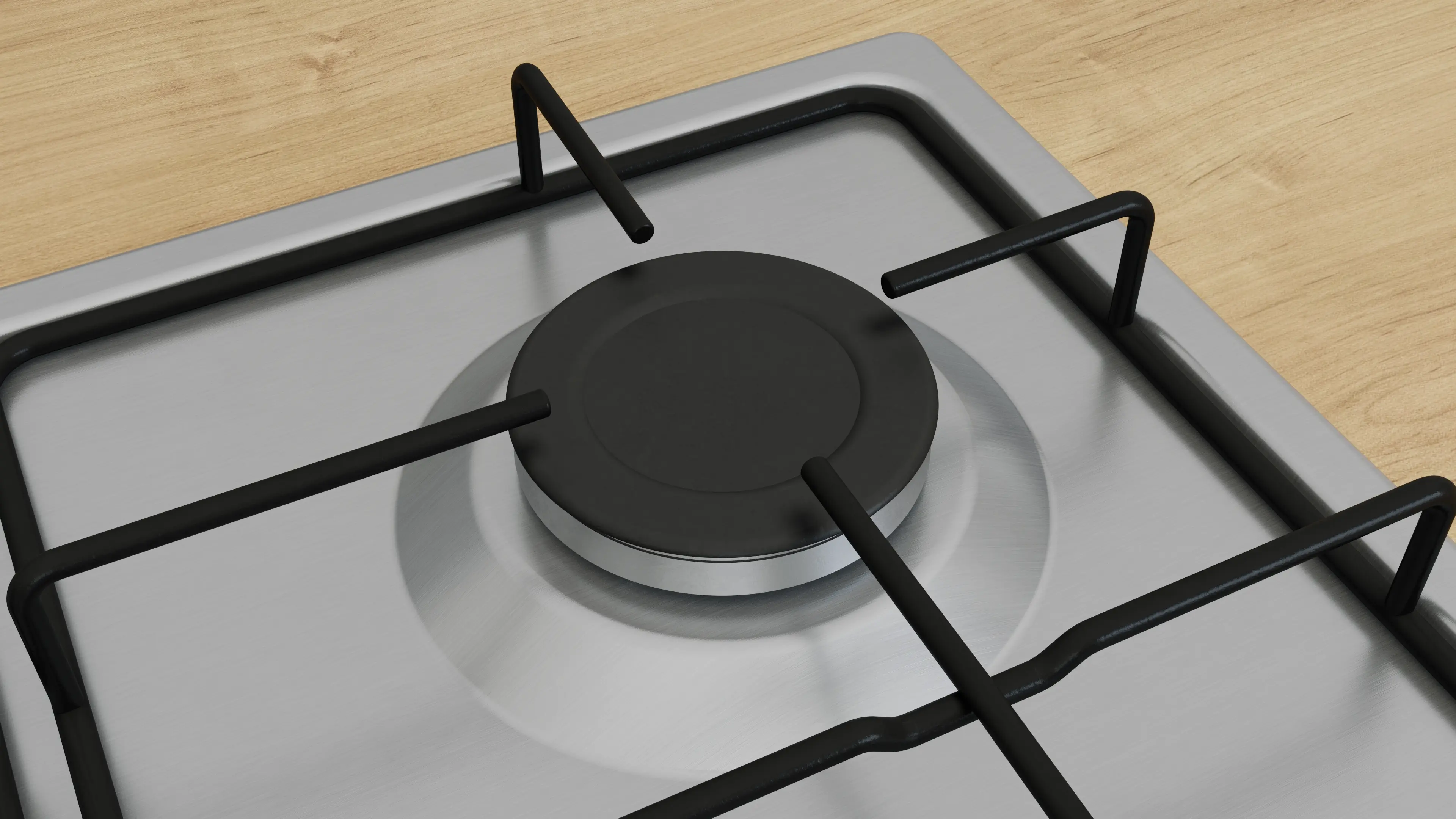 Kuchenka gazowa z czarnymi rusztami i palnikiem, na jasnej drewnianej powierzchni.