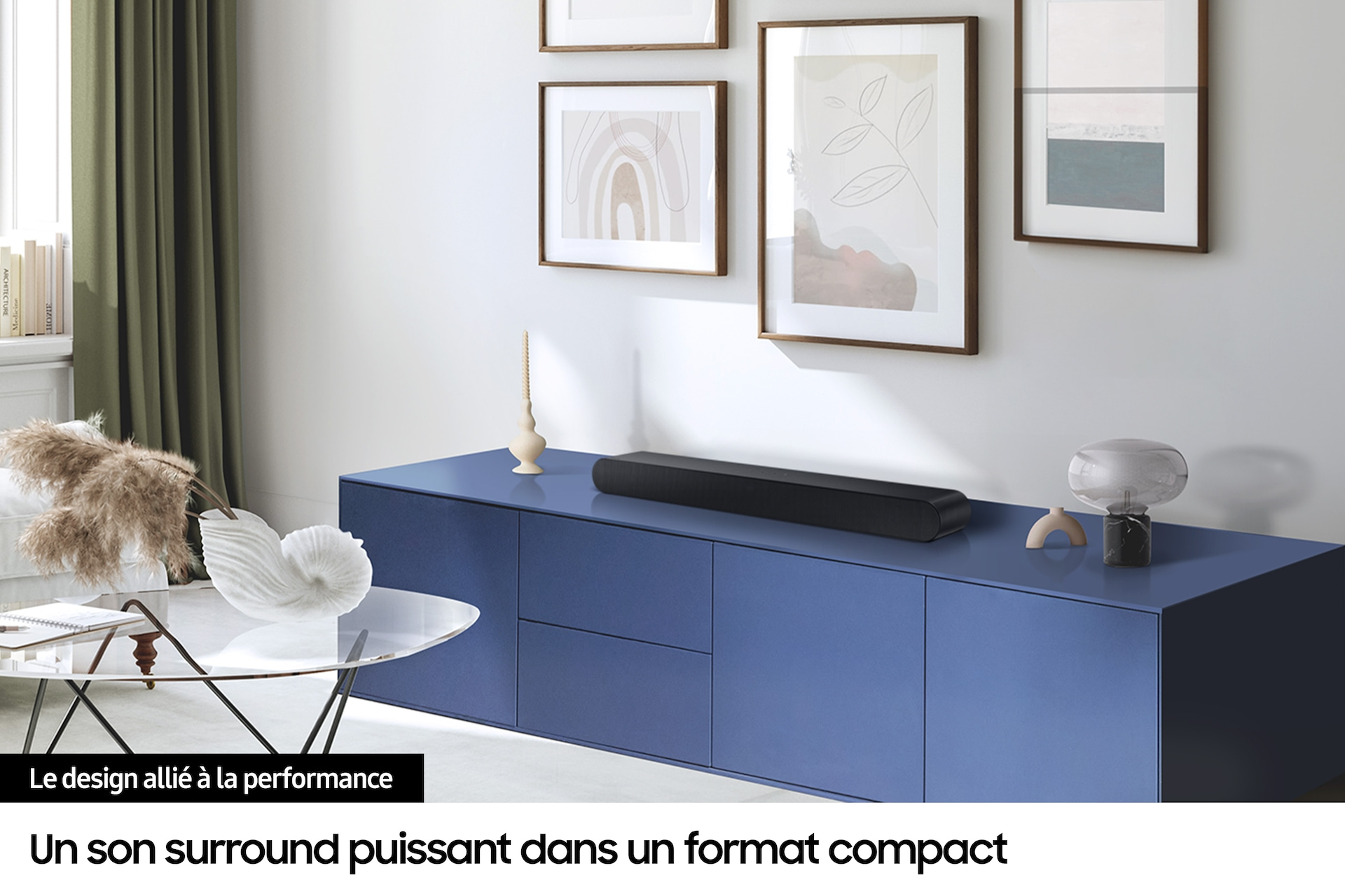 Soundbar na niebieskiej szafce, z oprawioną sztuką i elementami dekoracyjnymi.