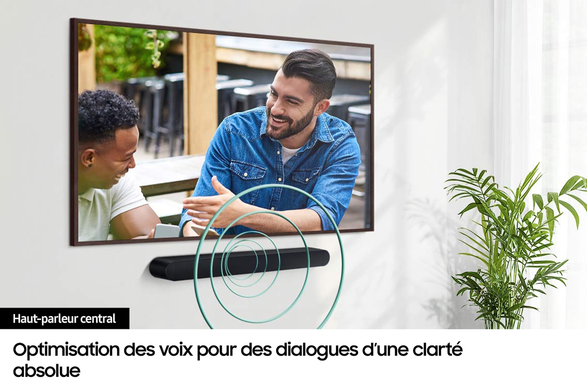 Dwóch mężczyzn uśmiechających się do telewizora z soundbarem poniżej, z zielonymi wizualizacjami fal dźwiękowych.