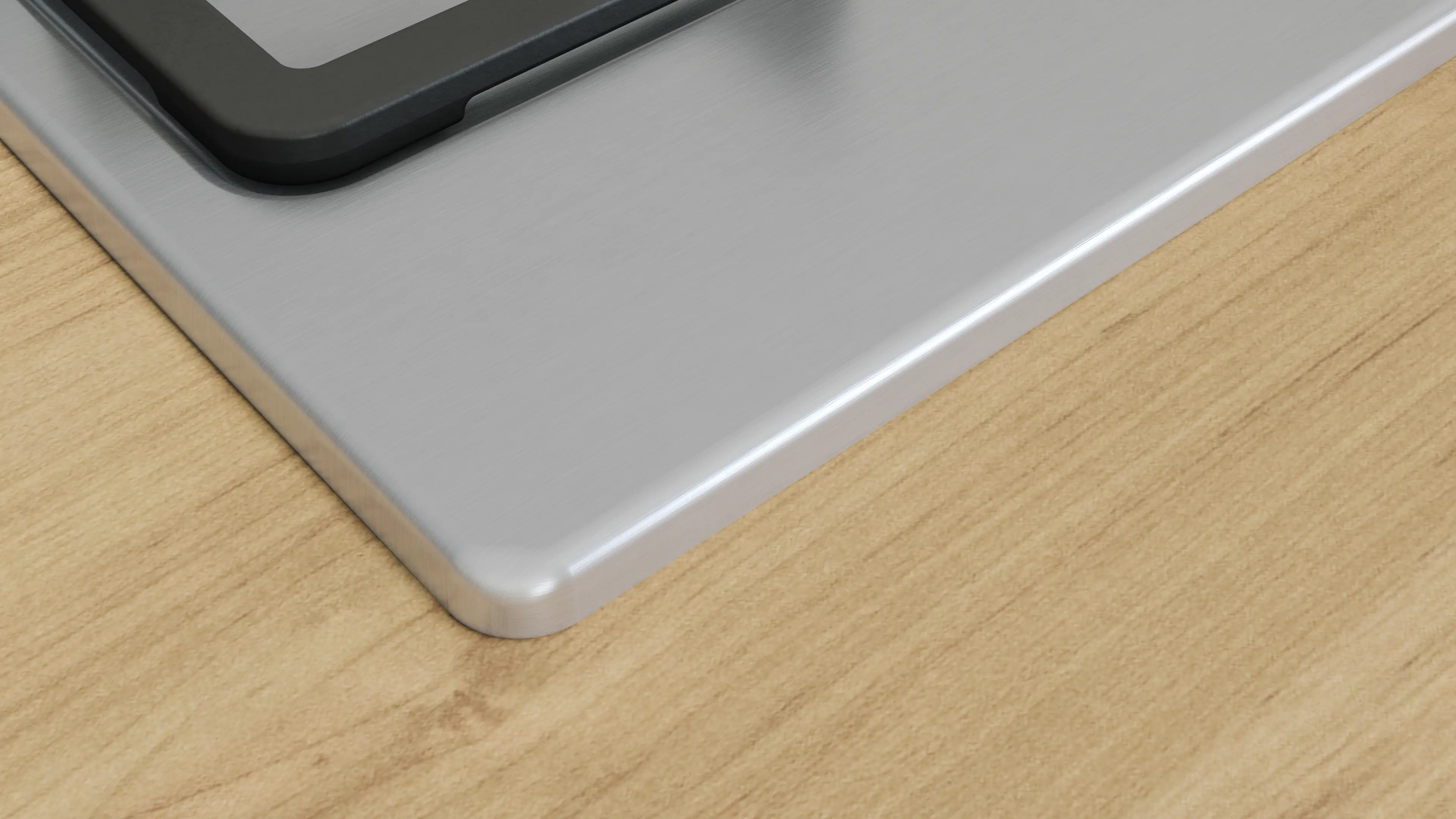 Zbliżenie srebrnej powierzchni płyty gazowej i krawędzi drewnianego blatu.