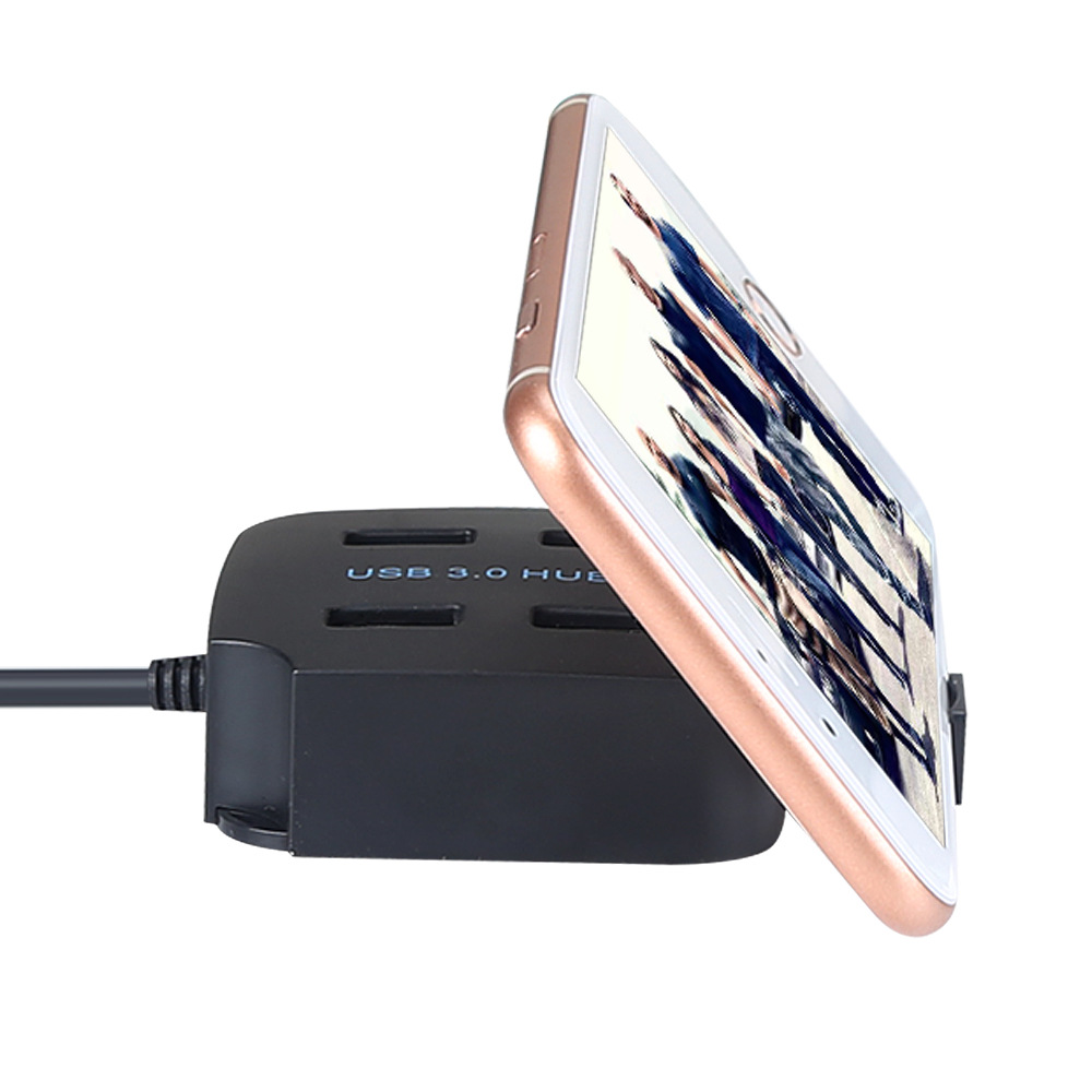 Ein schwarzer USB 3.0 Hub, der ein Telefon hält. Auf dem Telefon wird ein Bild angezeigt.