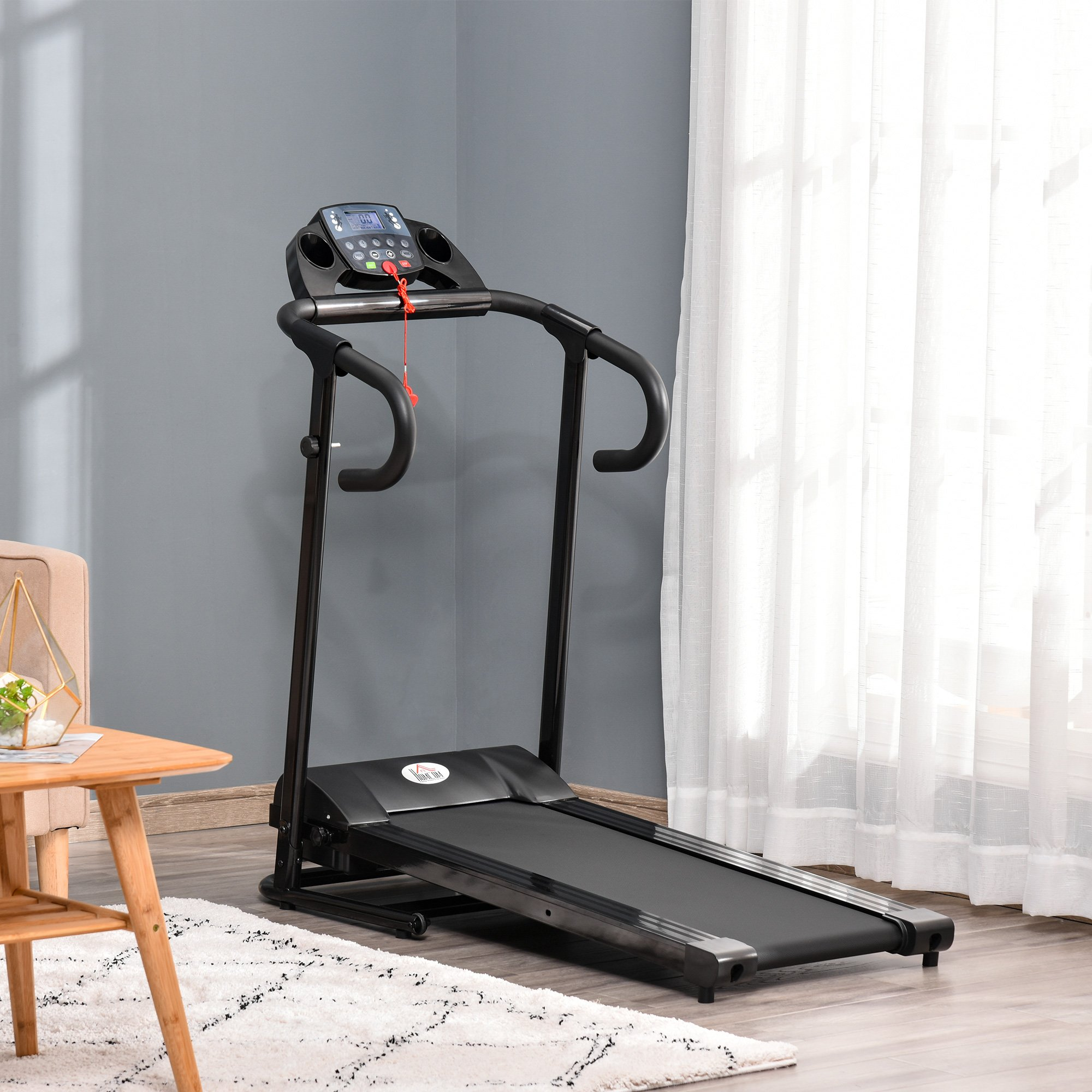 Laufband in einem Raum, mit grauer Wand und weißem Vorhang.