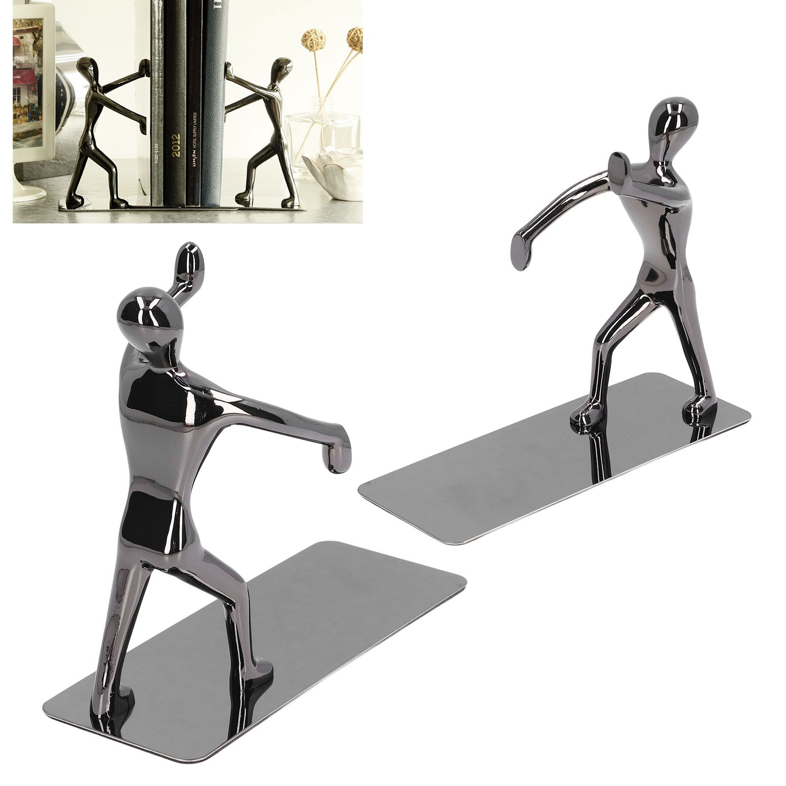 Zwei metallische Figuren in einer Pose, die Bücher halten. Sie stehen auf einer silbernen Basis, die Buchstützen ähnelt.
