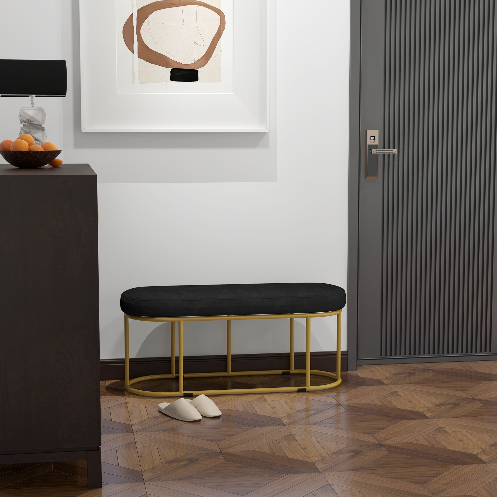 Eine schwarze Bank mit goldenen Beinen in einem Eingangsbereich, mit Dekor und Holzboden.