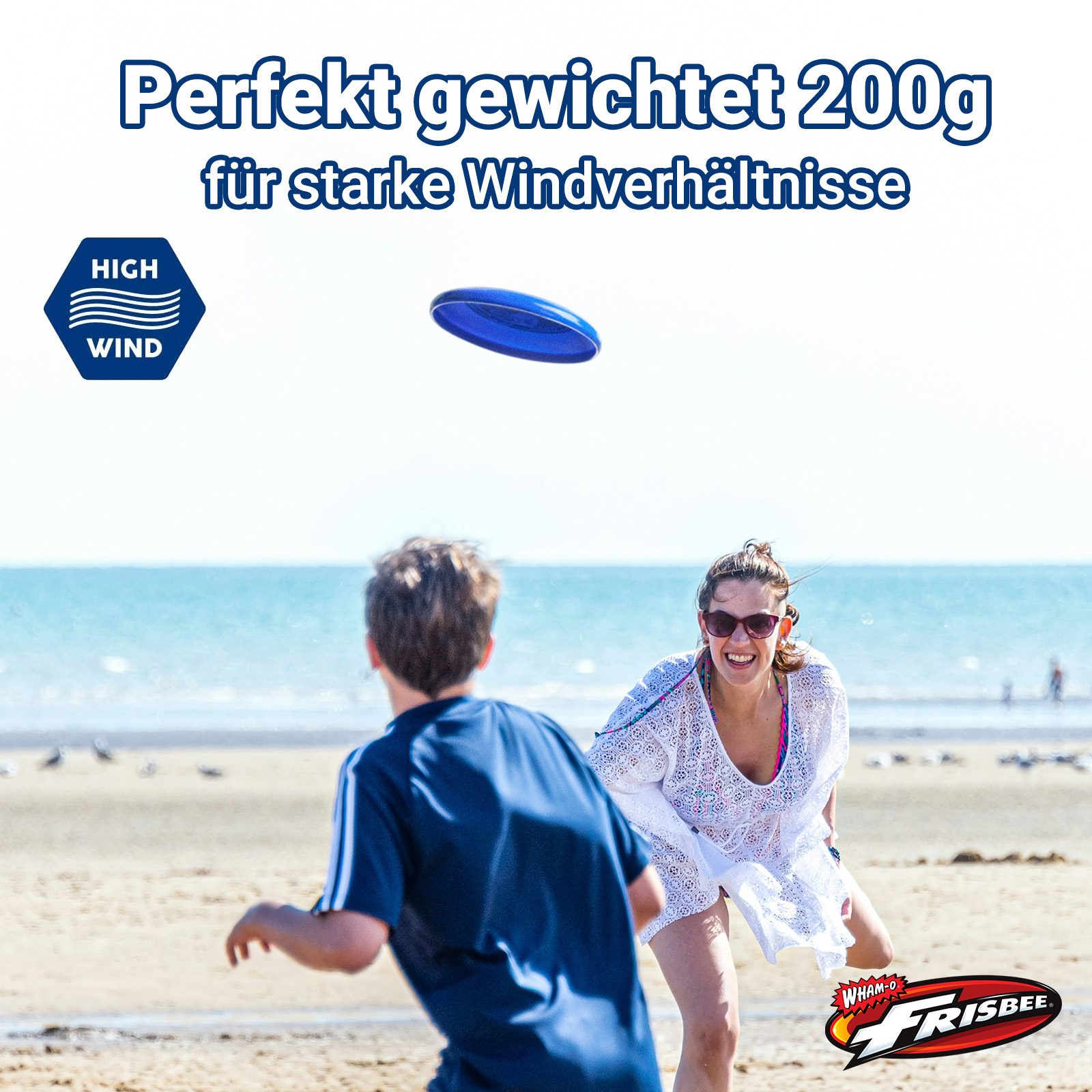 Zwei Personen spielen Frisbee am Strand. Blaue Frisbee in der Luft, mit deutschem Text.