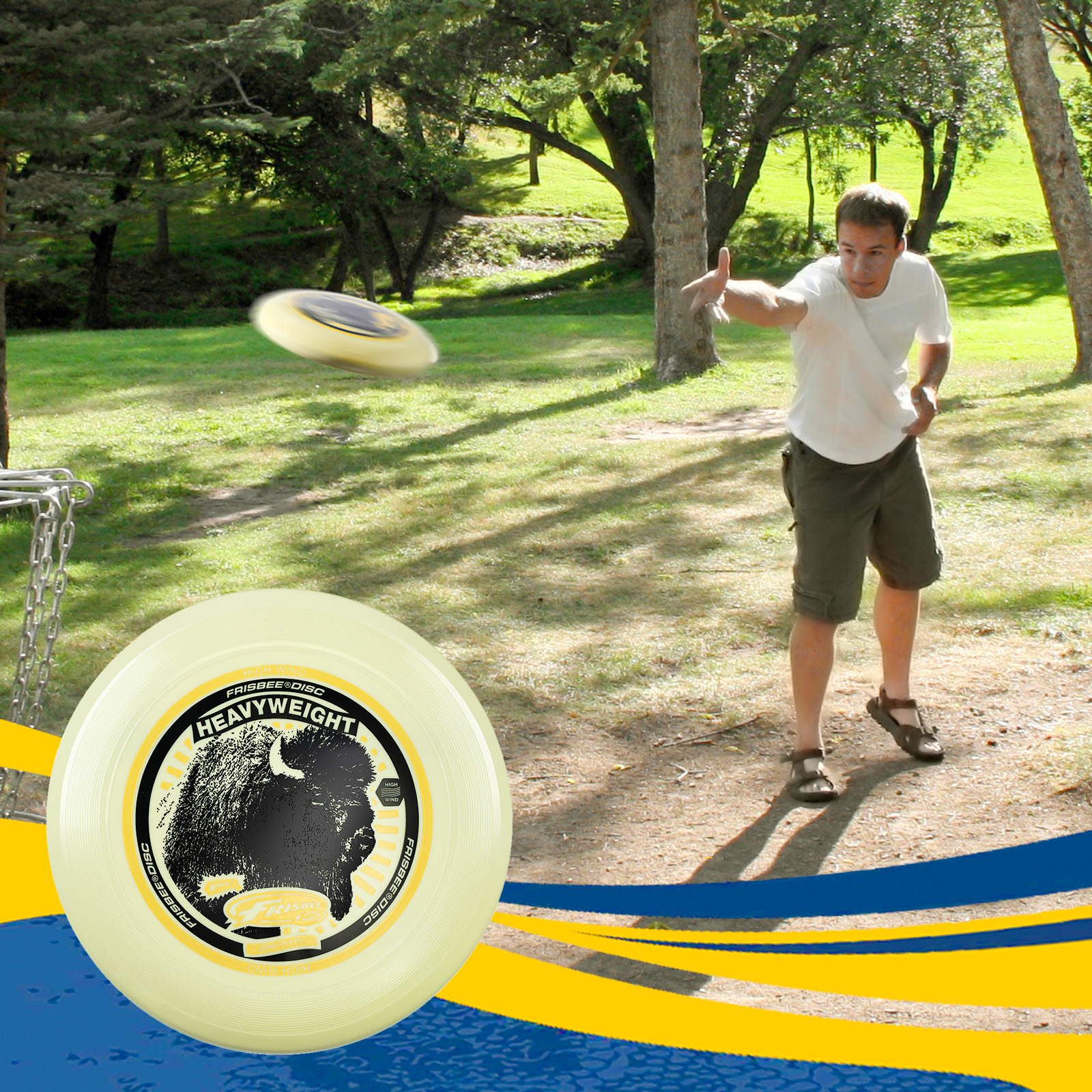 Uomo che lancia un frisbee giallo in un parco, con alberi e disco in primo piano.