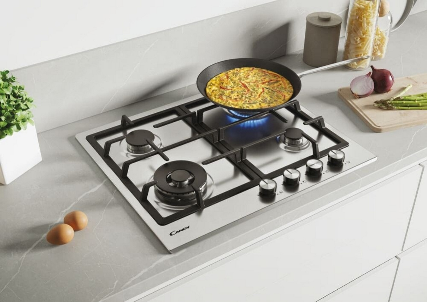 Kuchenka gazowa z patelnią z jedzeniem. Obecne są również jajka, warzywa i inne składniki.