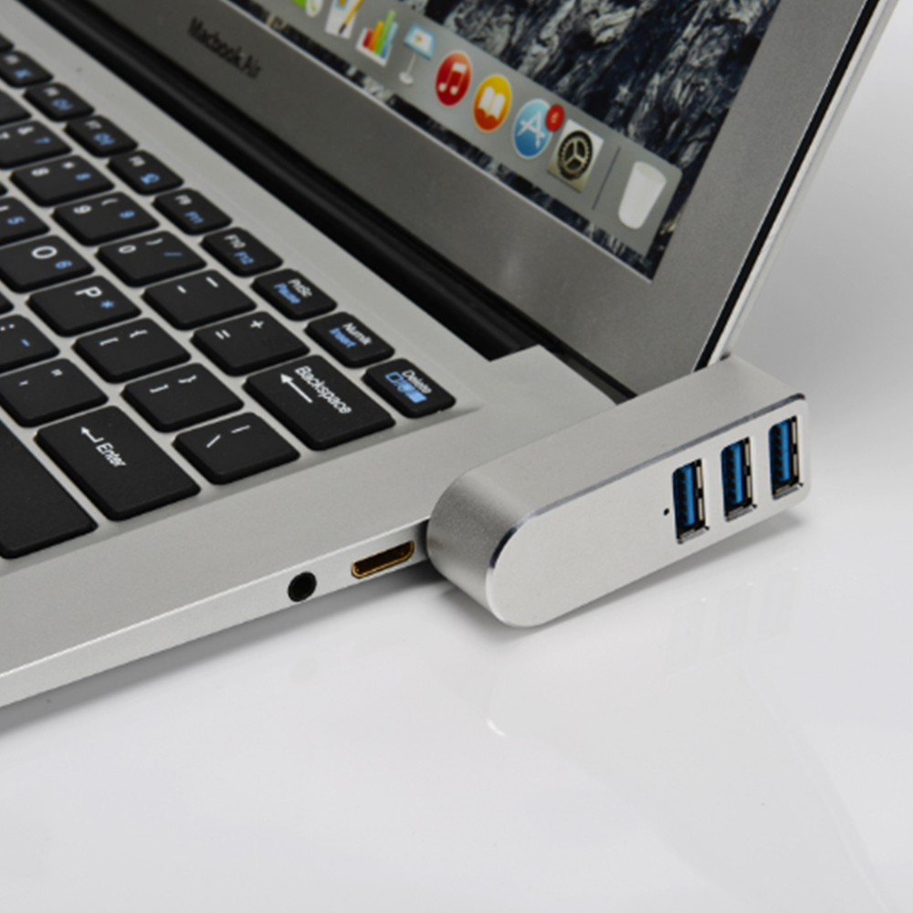 Ein silberner USB-Hub, der mit einem Laptop verbunden ist. Drei blaue USB-Anschlüsse sind sichtbar.