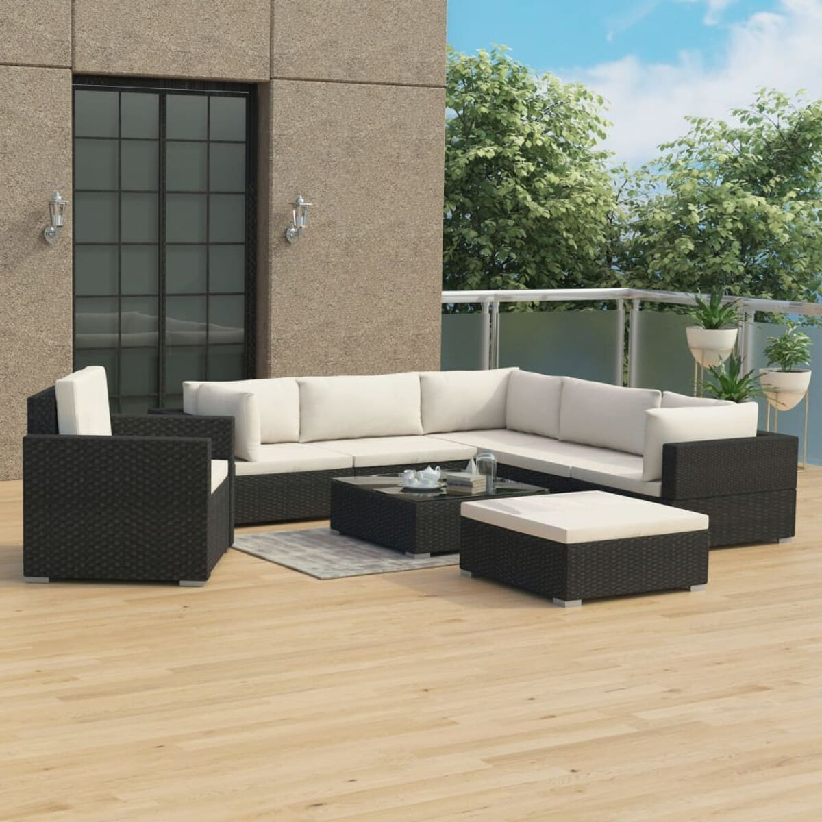 Set di mobili da esterno in rattan nero su un terrazzo in legno. Cuscini bianchi. Giorno soleggiato.