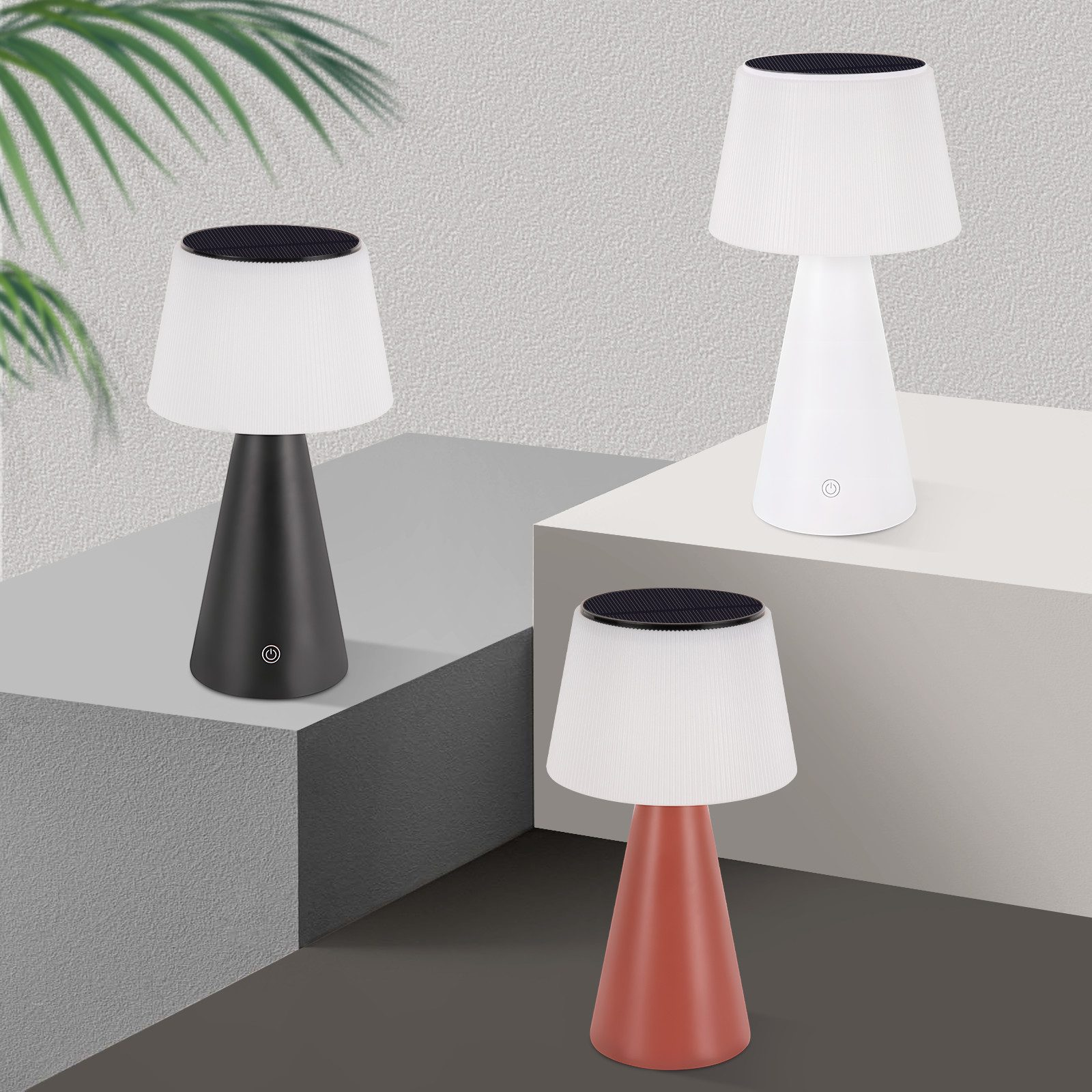 Trzy lampy w różnych kolorach (czarny, biały i czerwony) na szarej i białej powierzchni. Lampy są włączone.