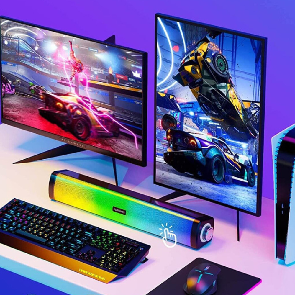 Ein Gaming-Setup mit Tastatur, Lautsprecher, Maus und zwei Monitoren.